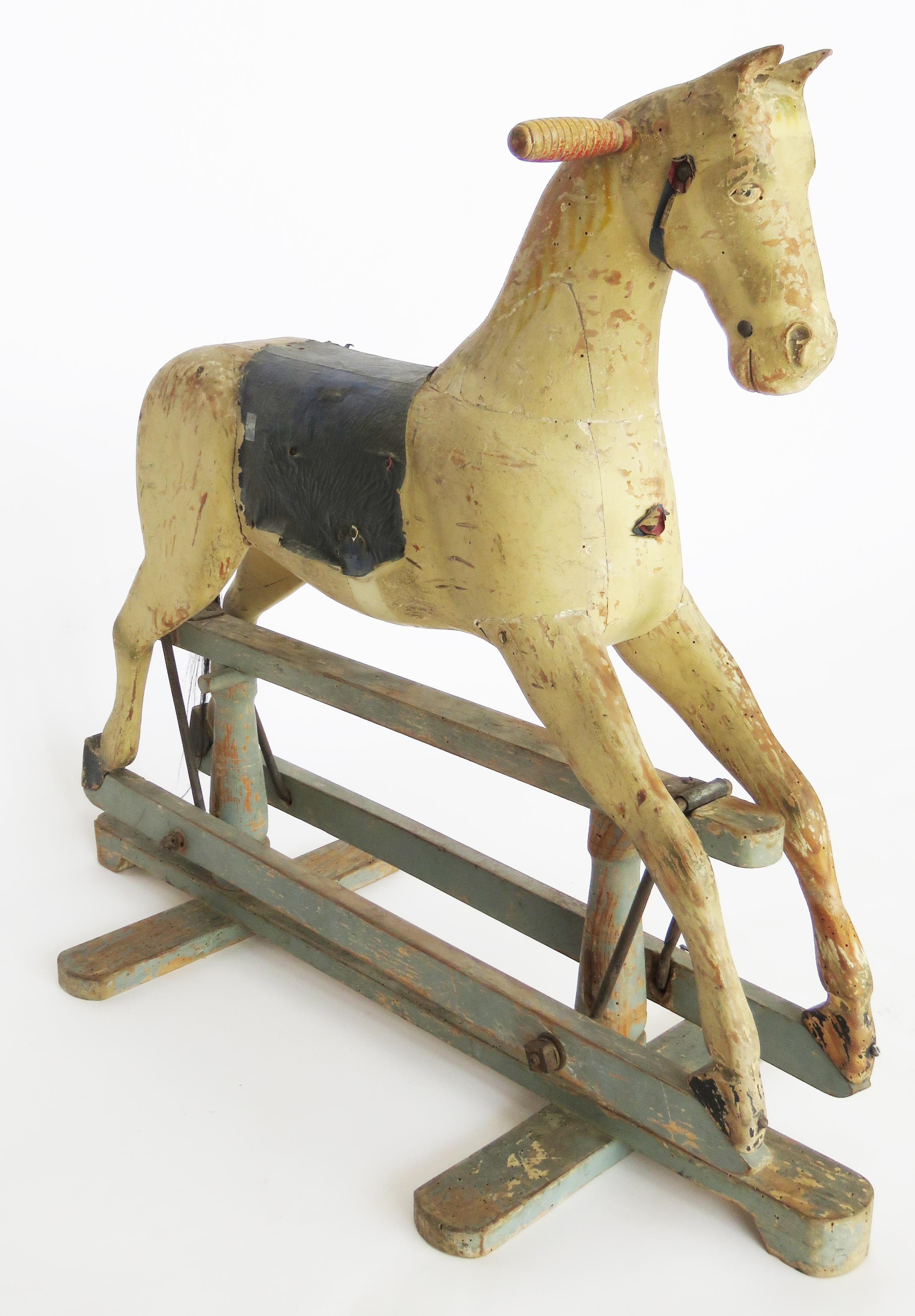 Wooden painted horse with leather saddle mounted on blue painted frame.