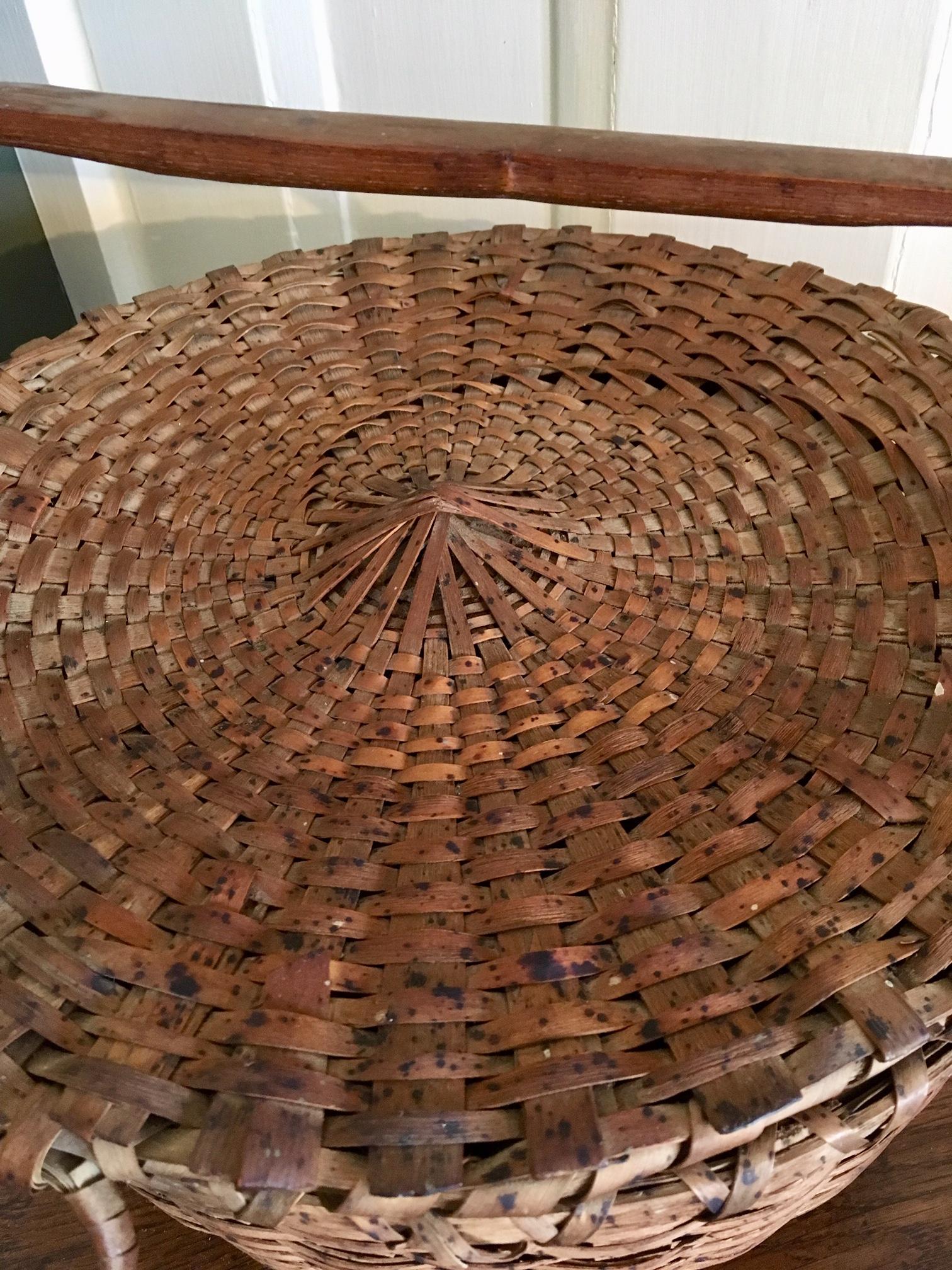 Very scarce 19th century woven splint covered basket for gathering feathers, certainly from New England, most likely by the Passamaquoddy Abenaki, circa 1840s-1850s. A round basket of shaved ash splint, with stationary carved wooden handle,
