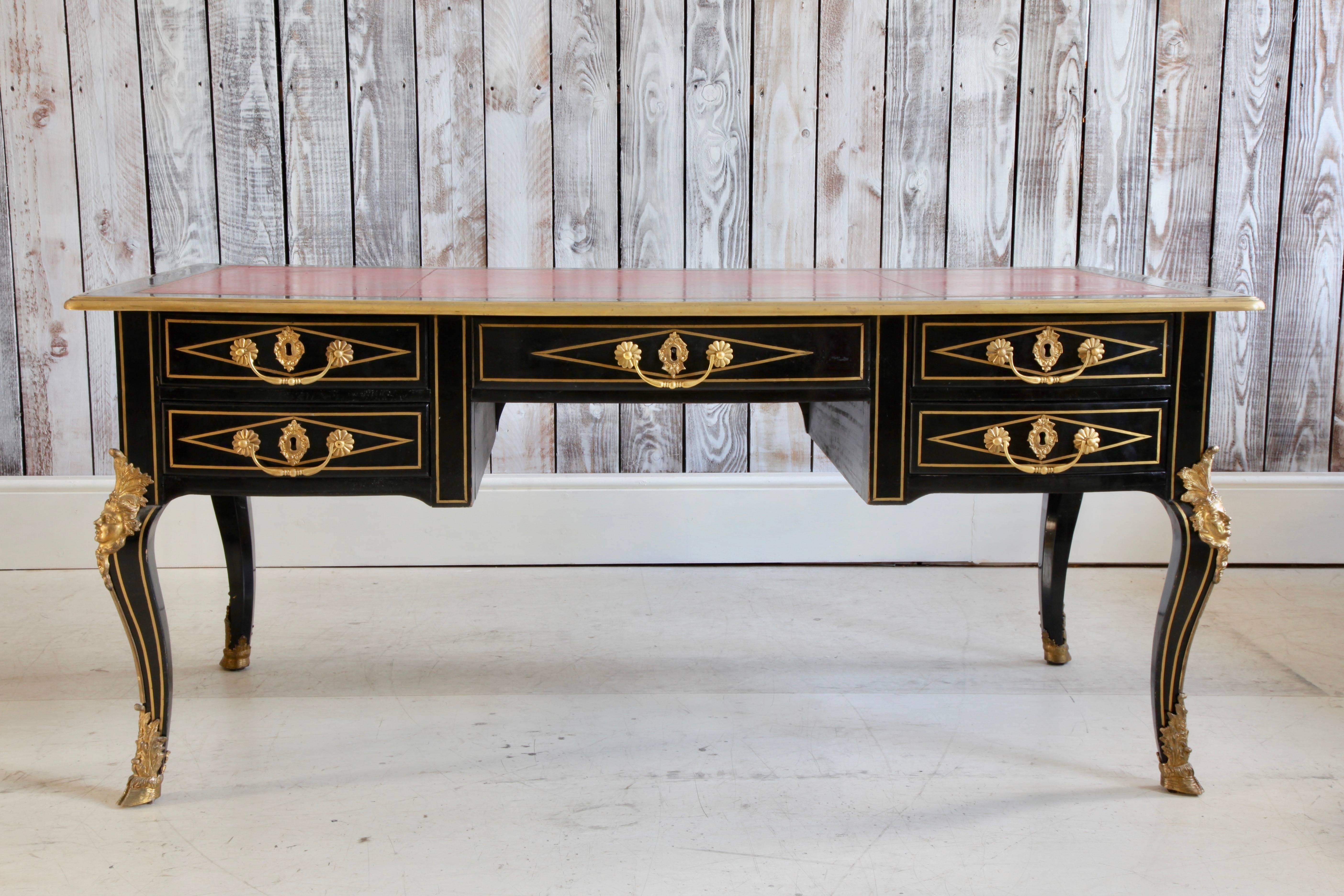 19th century, French writing desk designed in the Louis XIV Bureau Plat style made in ebonised wood. The charcoal black tones of the wood's patina makes for a striking contrast to the warm bright tones of the bronze inlay used to underscore the