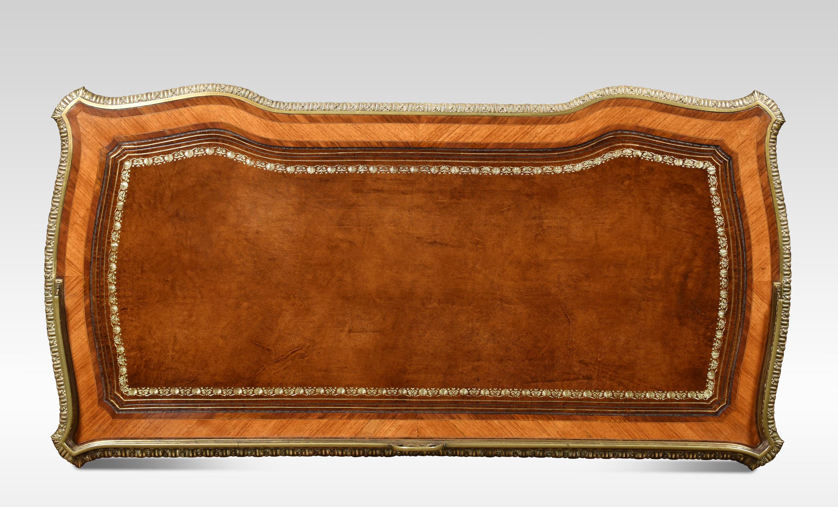 table à écrire du XIXe siècle, la galerie surélevée percée de trois quarts avec le monogramme SFJ, le plateau en cuir inséré entouré d'une bordure en laiton ciselé. Au-dessus d'un arrangement de cinq tiroirs, le tout reposant sur de minces supports