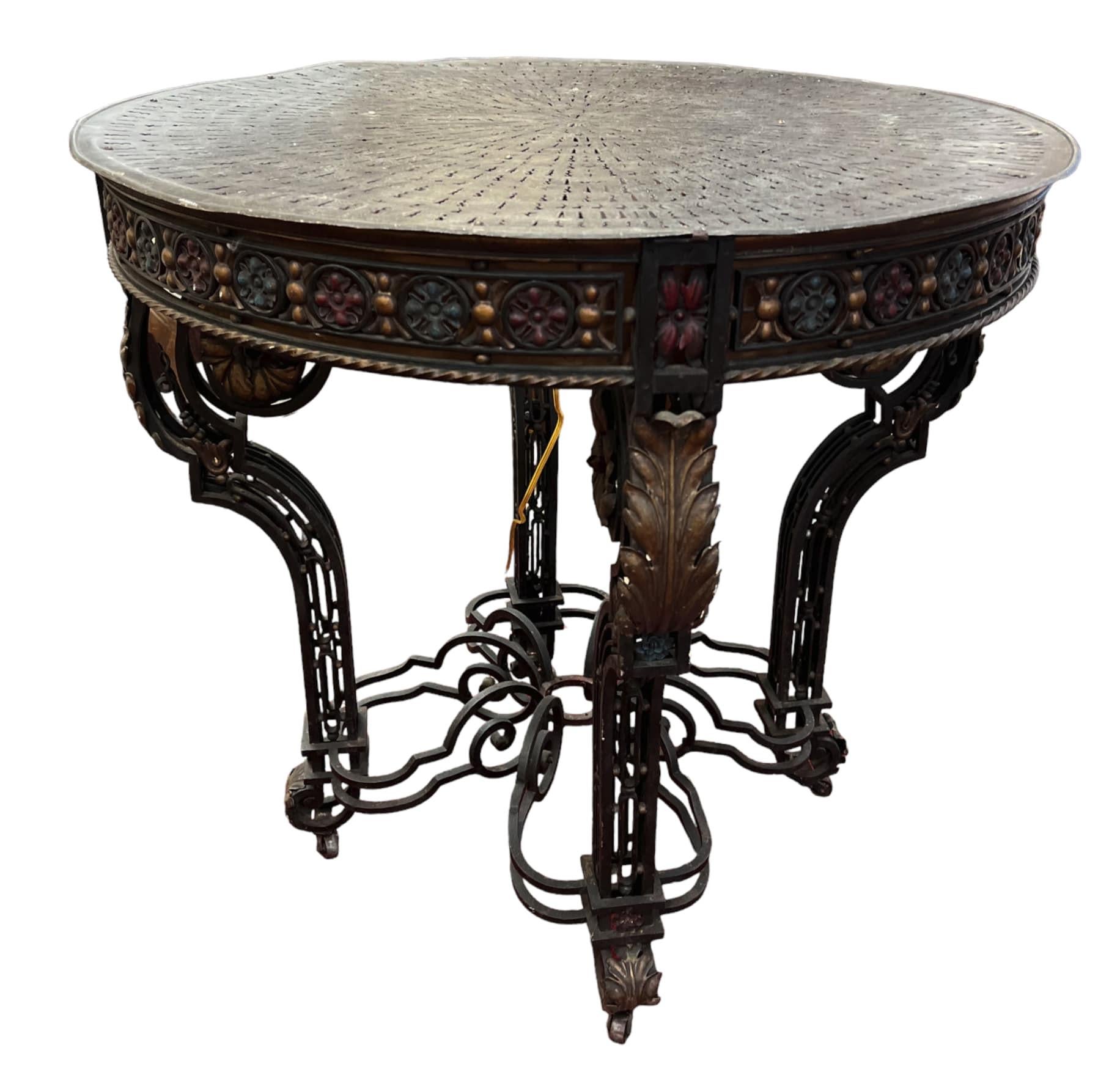 Handcrafted circa 1875 by a metal artist schooled in Europe, the antique round wrought iron table features a built-in light fixture (110 V), added at a later point, which makes this table incredibly unique. The 32