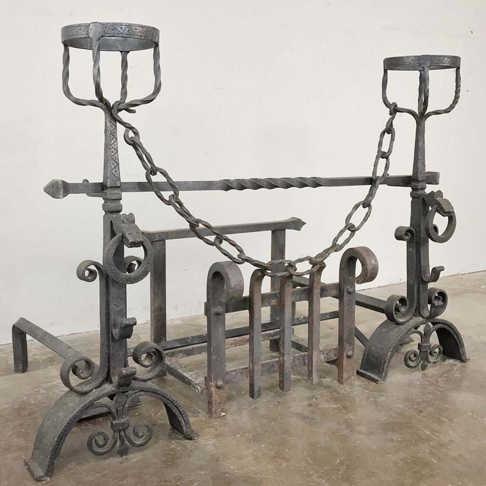 19th century wrought iron andiron fireplace set includes the kindling cradle with two andirons fitted with pot and candle holders. Such a wonderfully crafted complete set is uncommon, especially one that exhibits such a high degree of craftsmanship