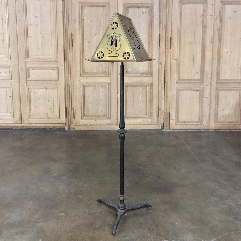 19th century wrought iron and brass music stand is a splendid example of hand-craftsmanship, with a sturdy (and heavy) forged iron base with tripod legs supporting the solid brass two-sided book or music stand above. On the sides are pierced symbols