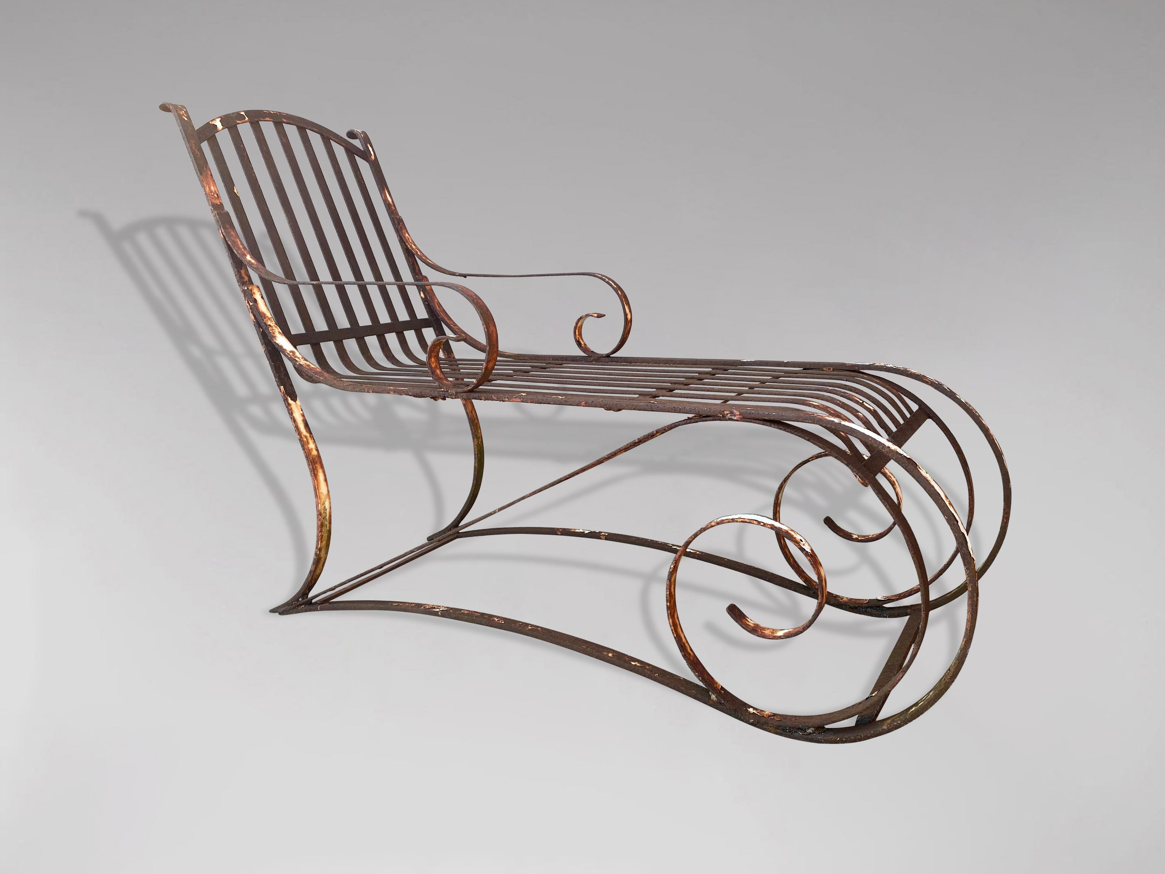 A beautiful 19th century French wrought iron chaise longue lounger of curved form. Heavily constructed with scrolling back, roll over arms and scrolling accents along the front. Completely original, in very strong condition with lovely proportions.