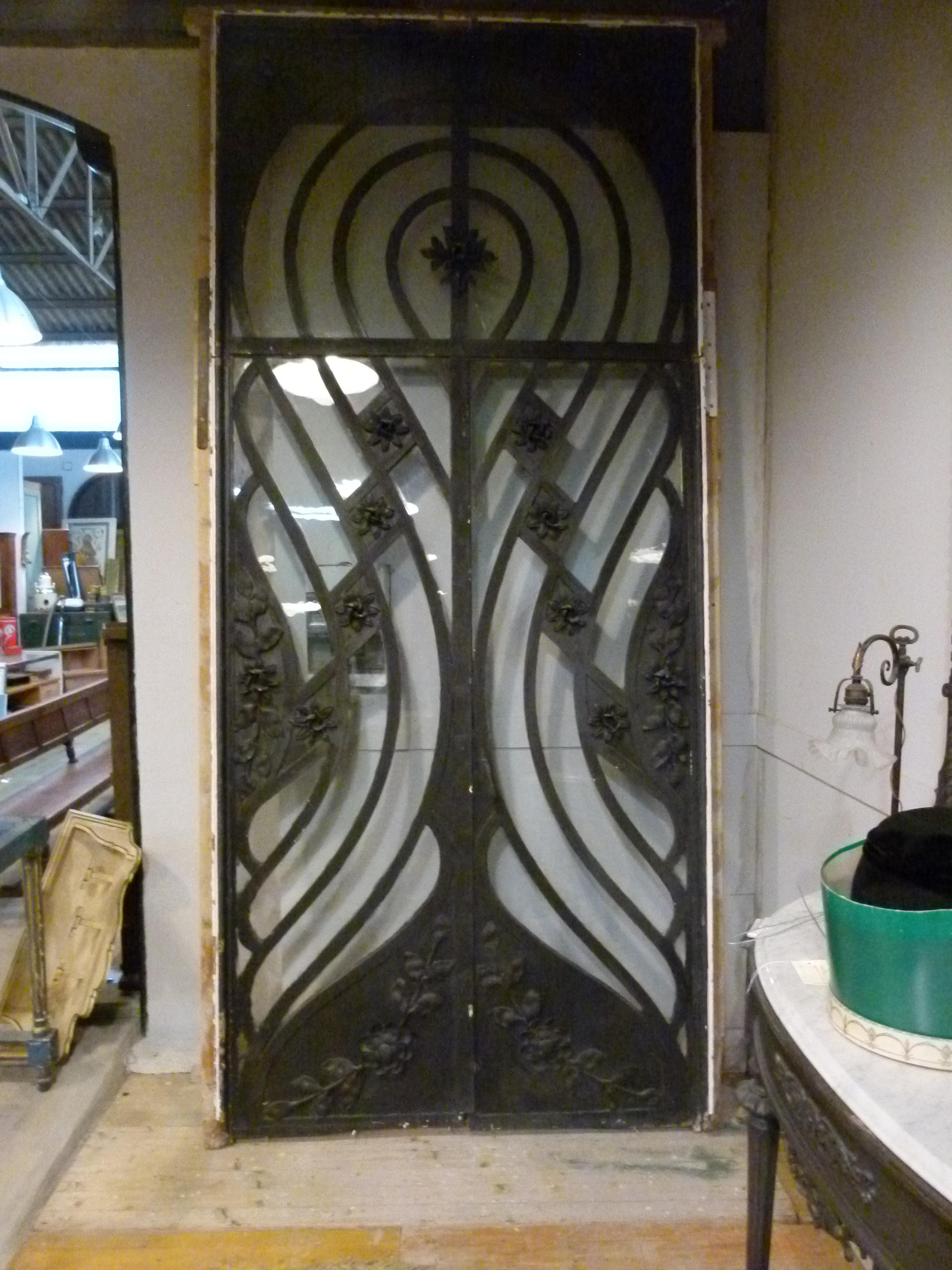 schmiedeeiserne Doppeltür aus dem 19. Jahrhundert im Jugendstil.
Eine große Doppeltür, die zum Eingang eines vornehmen Hauses in Barcelona gehörte. Es besteht aus floralen Verzierungen und symmetrischen Linien, die die Tür in der Art und Weise
