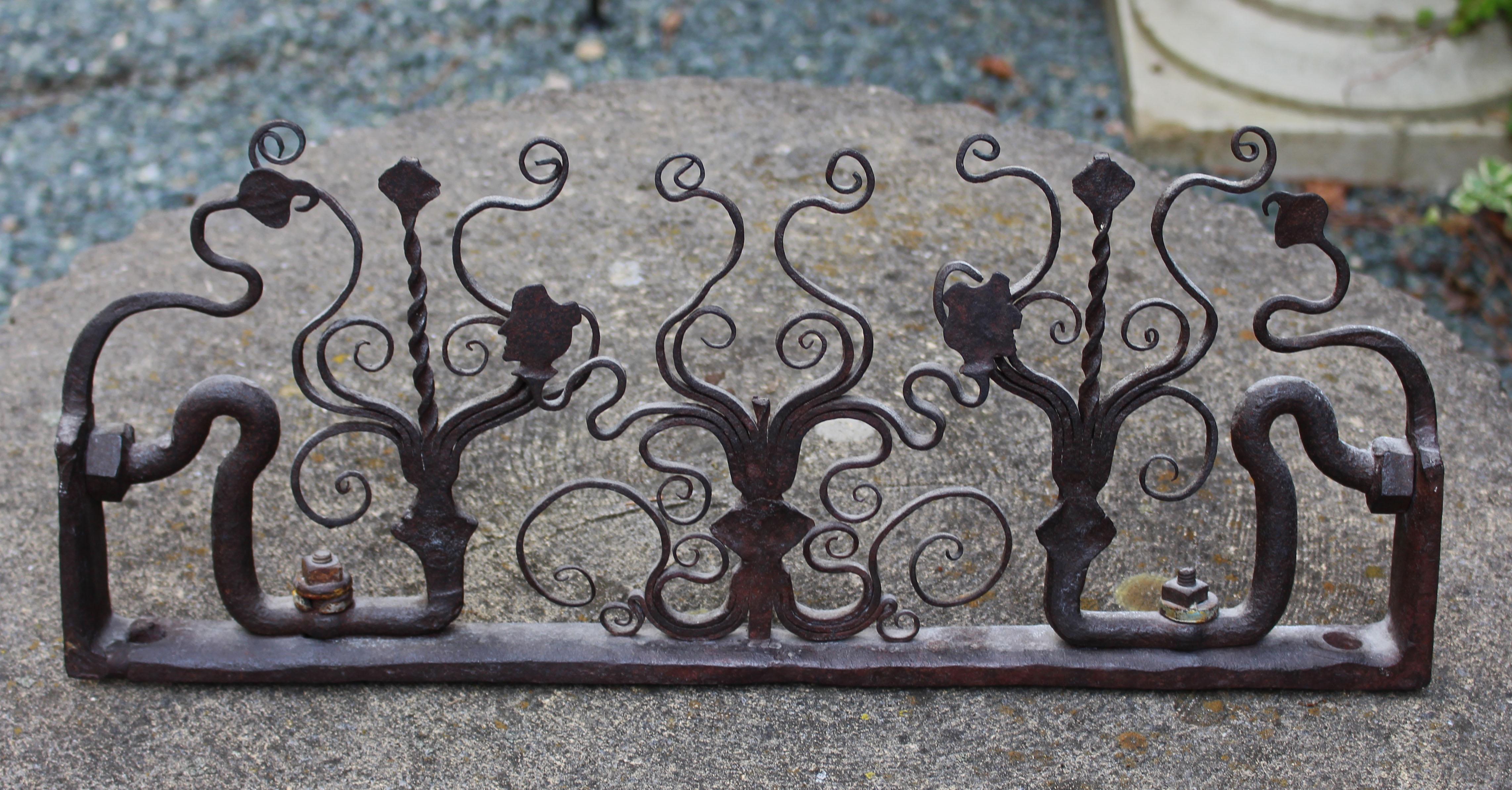 19th century wrought iron fence fragment, Continental likely Portuguese. Decorated with scrolls & 2 opposing classical busts. Fun in front of a fireplace, kitchen backsplash or accent decoration. Estate of Jean Anderson, noted cookbook author. 21