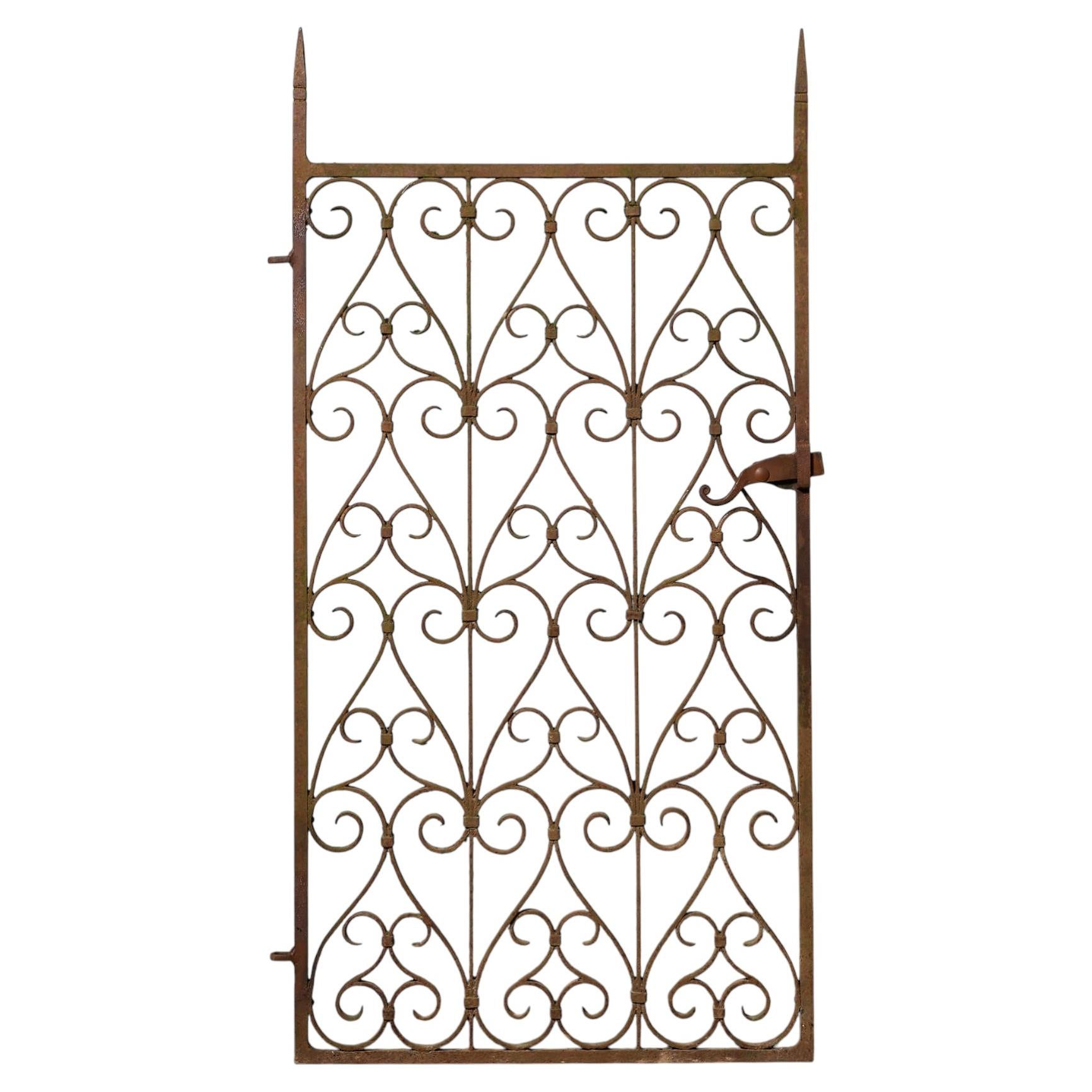 Puerta lateral de hierro forjado del siglo XIX