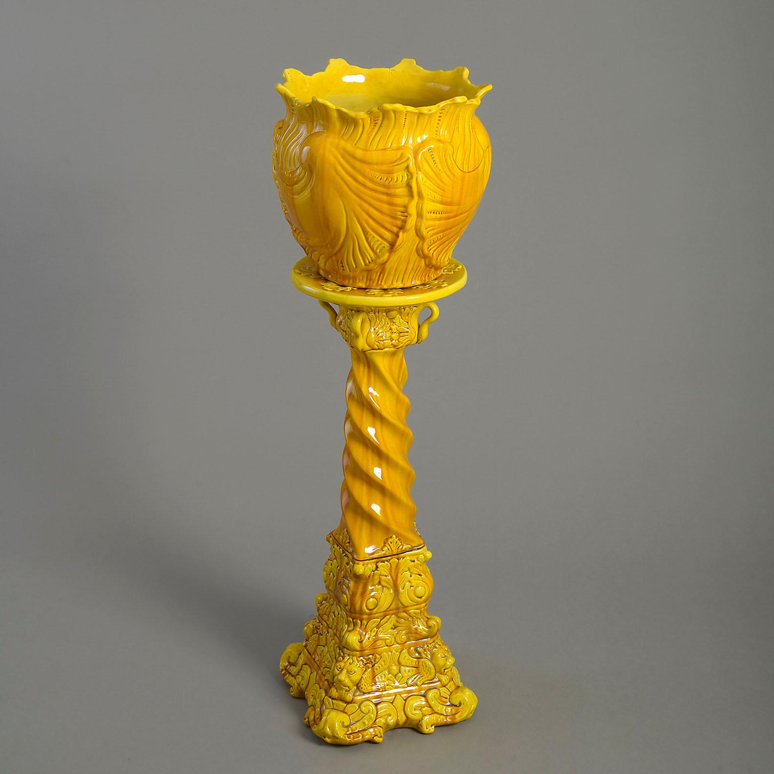 A rare 19th century yellow Minton pottery jardiniere on stand, in two parts, the shell planter set upon a tapering square base, profusely decorated with swans, lion masks and a swirling column.