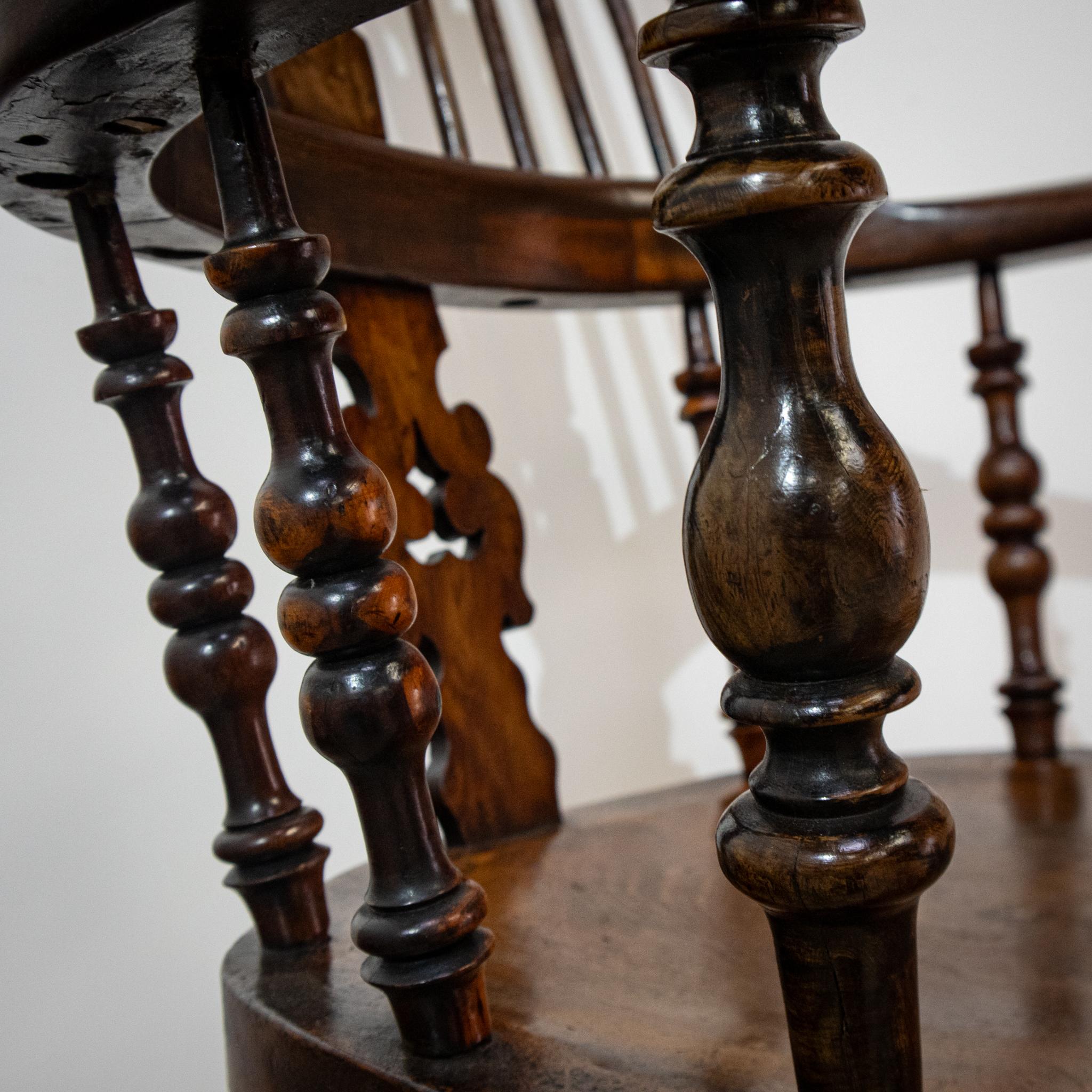 Un bel exemple de chaise Windsor traditionnelle à dossier haut, avec de larges accoudoirs aux extrémités tactiles et un dossier sculpté et percé. De façon inhabituelle, les fuseaux inférieurs sont tournés et s'accordent avec les pieds tournés, qui