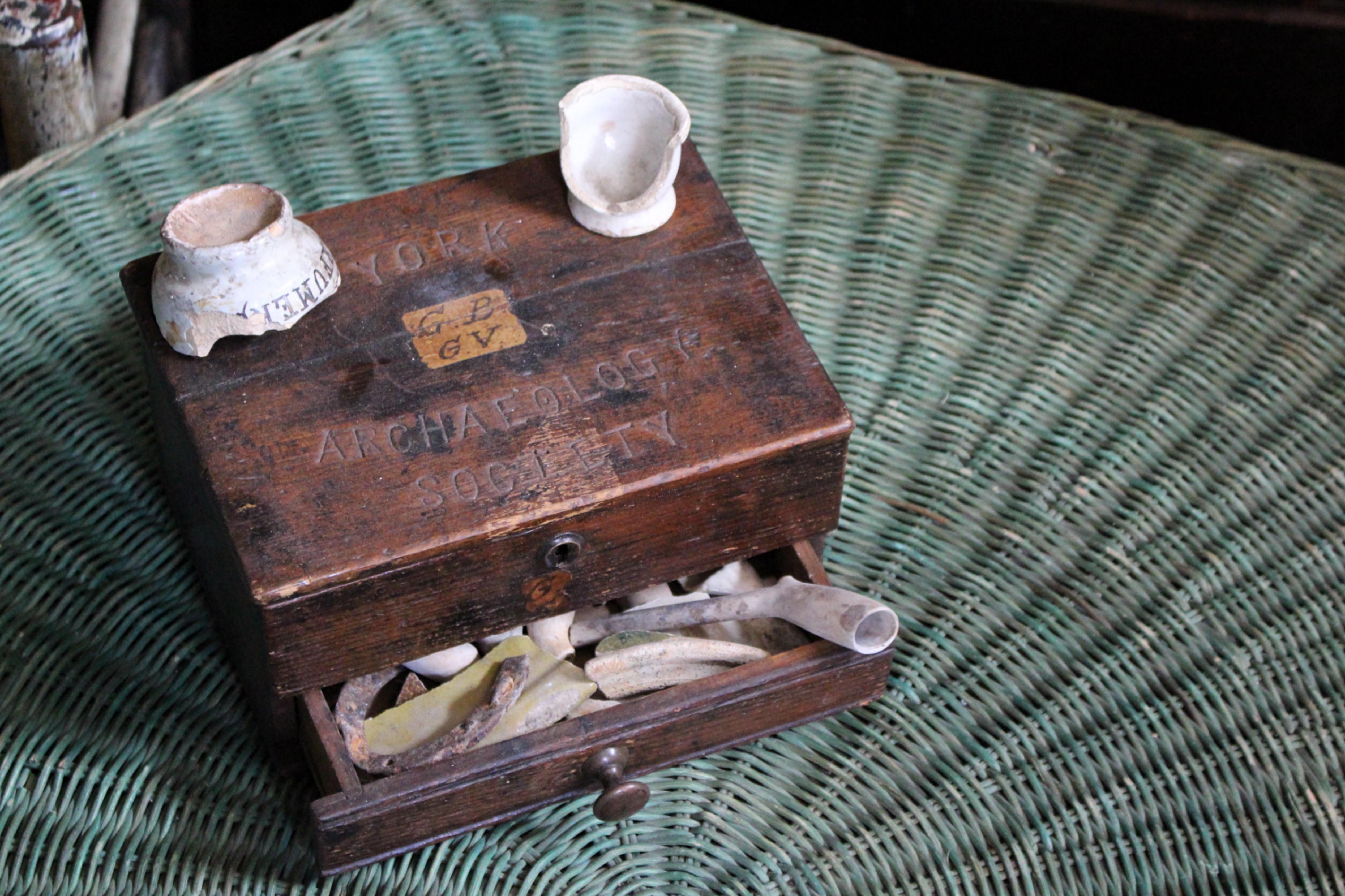Eine charmante kleine Sammlerbox aus Eichenholz mit der Aufschrift 'YORK ARCHAEOLOGY SOCIETY'.

Papieretikett mit Tintenaufschrift GB GV, der Scharnierdeckel und die Schublade mit alten Keramikscherben, Pfeifen

11 cm hoch, 22 cm breit, 16,5 cm tief