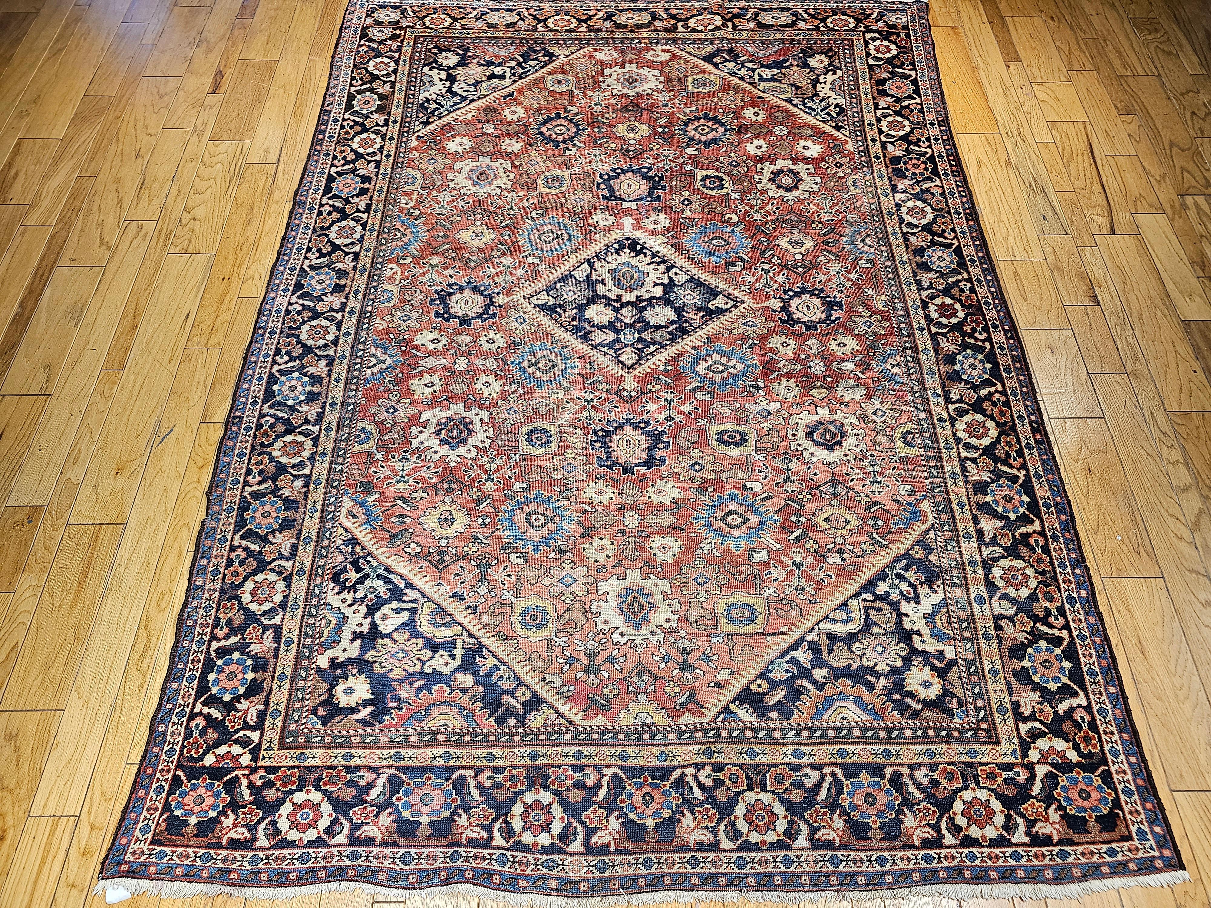 The Ziegler Mahal Sultanabad rugs are world renowned for their ageless beauty. This antique Mahal Sultanabad from the late 19th century has an overall design with a rust field and blue border. The large forms in white, blue, pink, and yellow