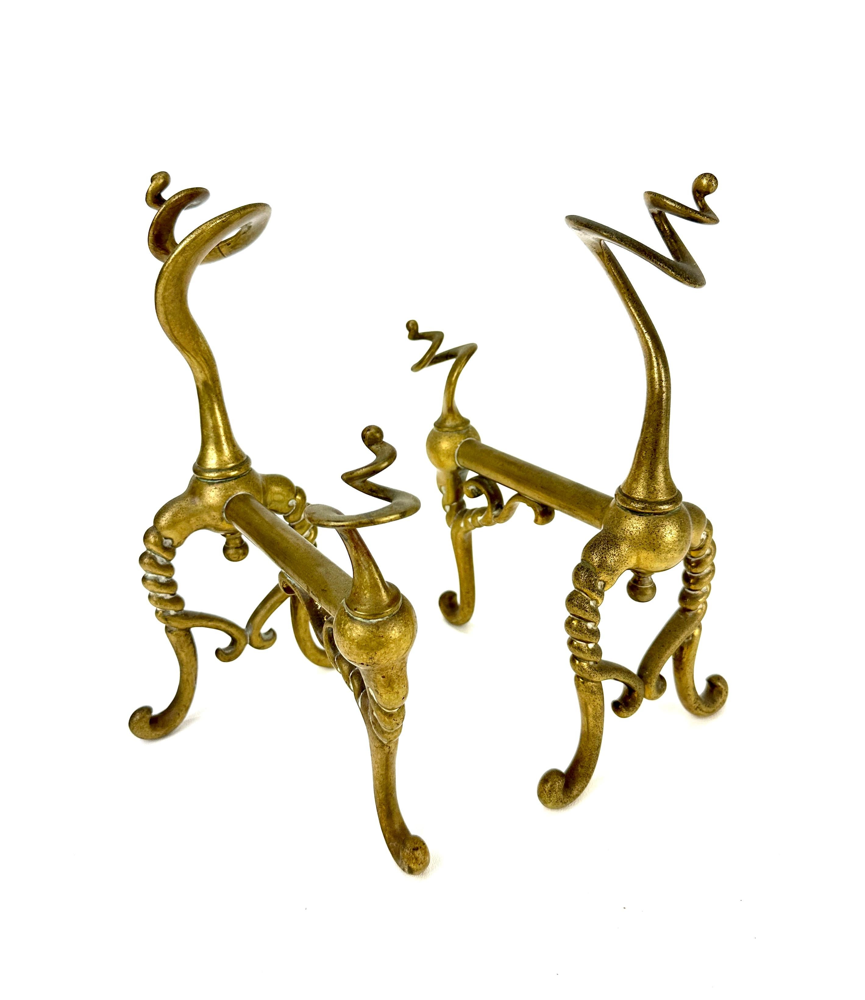 Fabulous pair of late 19th Century cast brass fire dogs with a charming zoomorphic aesthetic.  The unique form offers twists and turns in all the right places and curlicues as a perfect accent.  Unsigned though appears to be French in