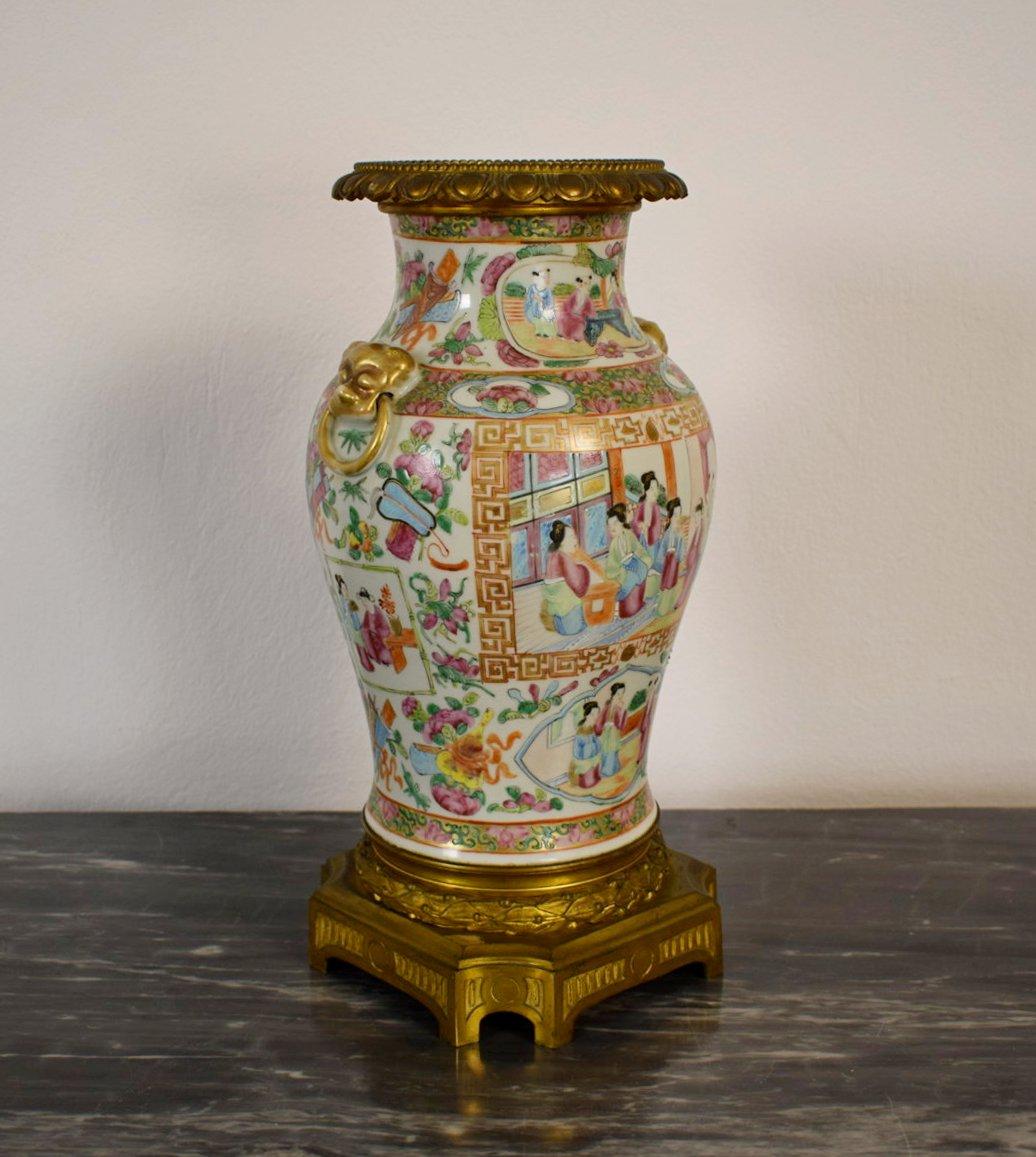 This elegant vase was made of porcelain in the 19th century in Canton, China.
The porcelain is decorated with typical polychrome paintings depicting court scenes, flowers, leaves, inscribed in golden reserves and golden decorations in relief. The
