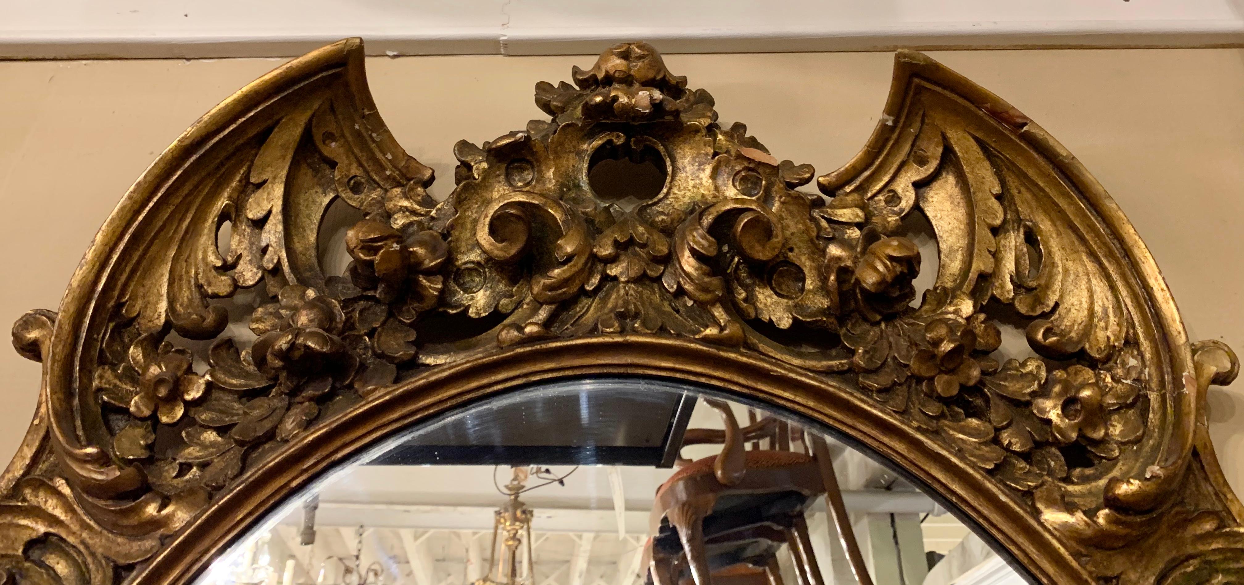 19th-early 20th century carved oval giltwood wall / console mirror having an elaborately carved wood and gesso frame.

Greg
SXAX/ESXX.