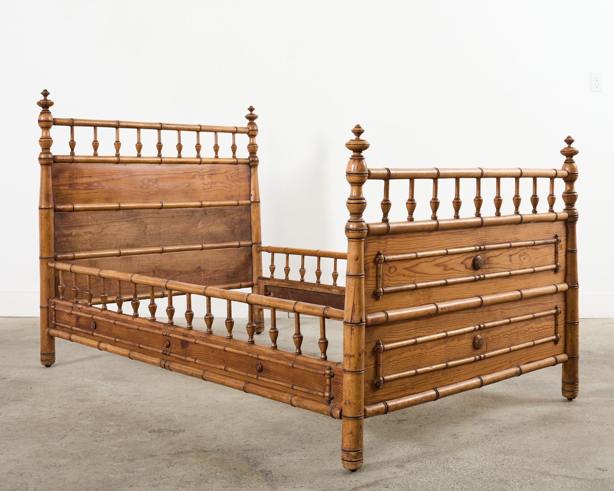 Handsome late 19th century English Aesthetic movement period faux bamboo bed crafted from pine. The bed features a large head and foot board with faux bamboo turned supports and spindle shaped finials. The headboard is 48 inches high and the