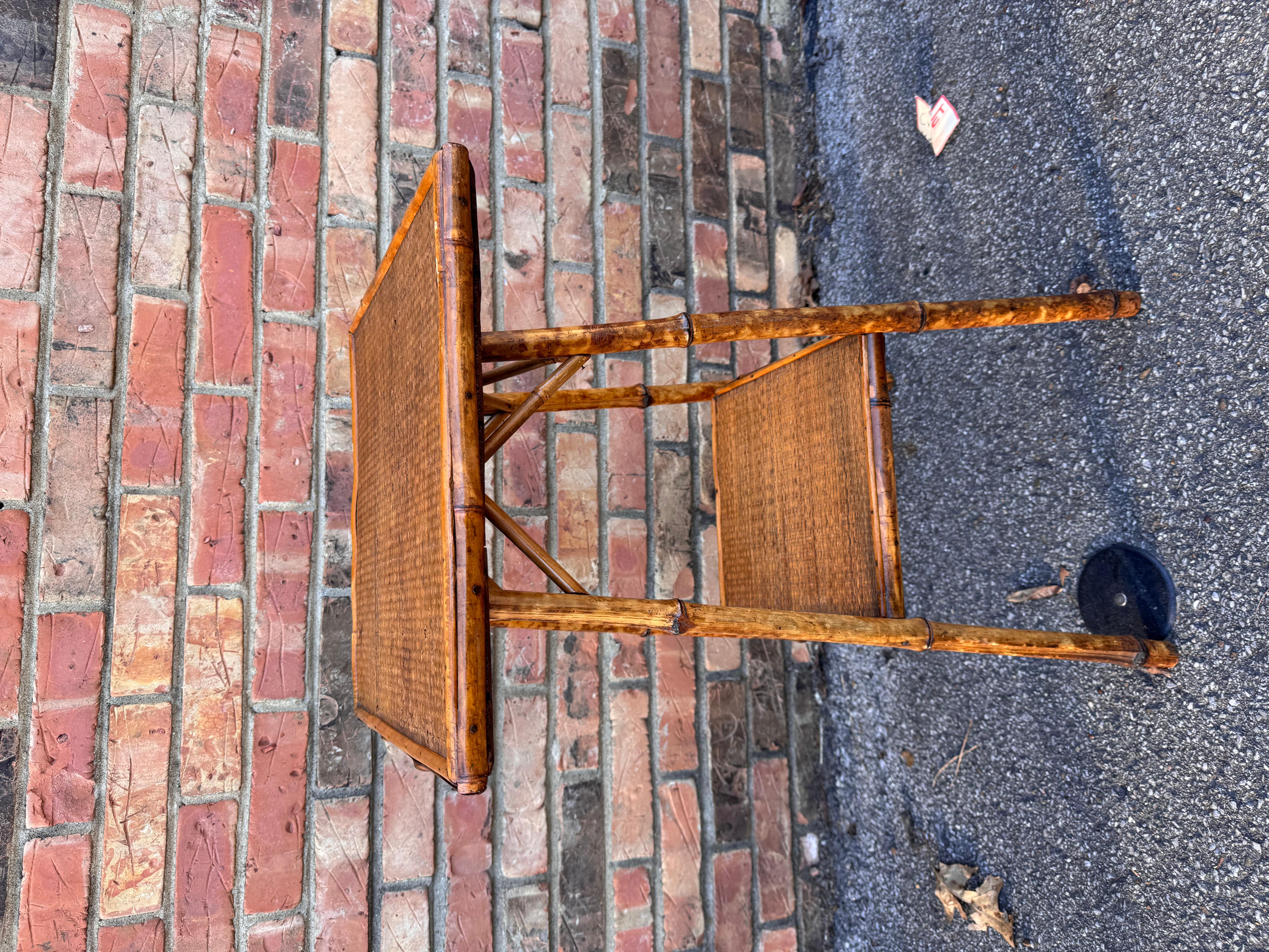 This is a beautiful 19th century English bamboo side table! Tables like these make excellent accent pieces because their color and style is so versatile. The dark hues of the burnt bamboo pair perfectly with the lighter golden of the rattan top and