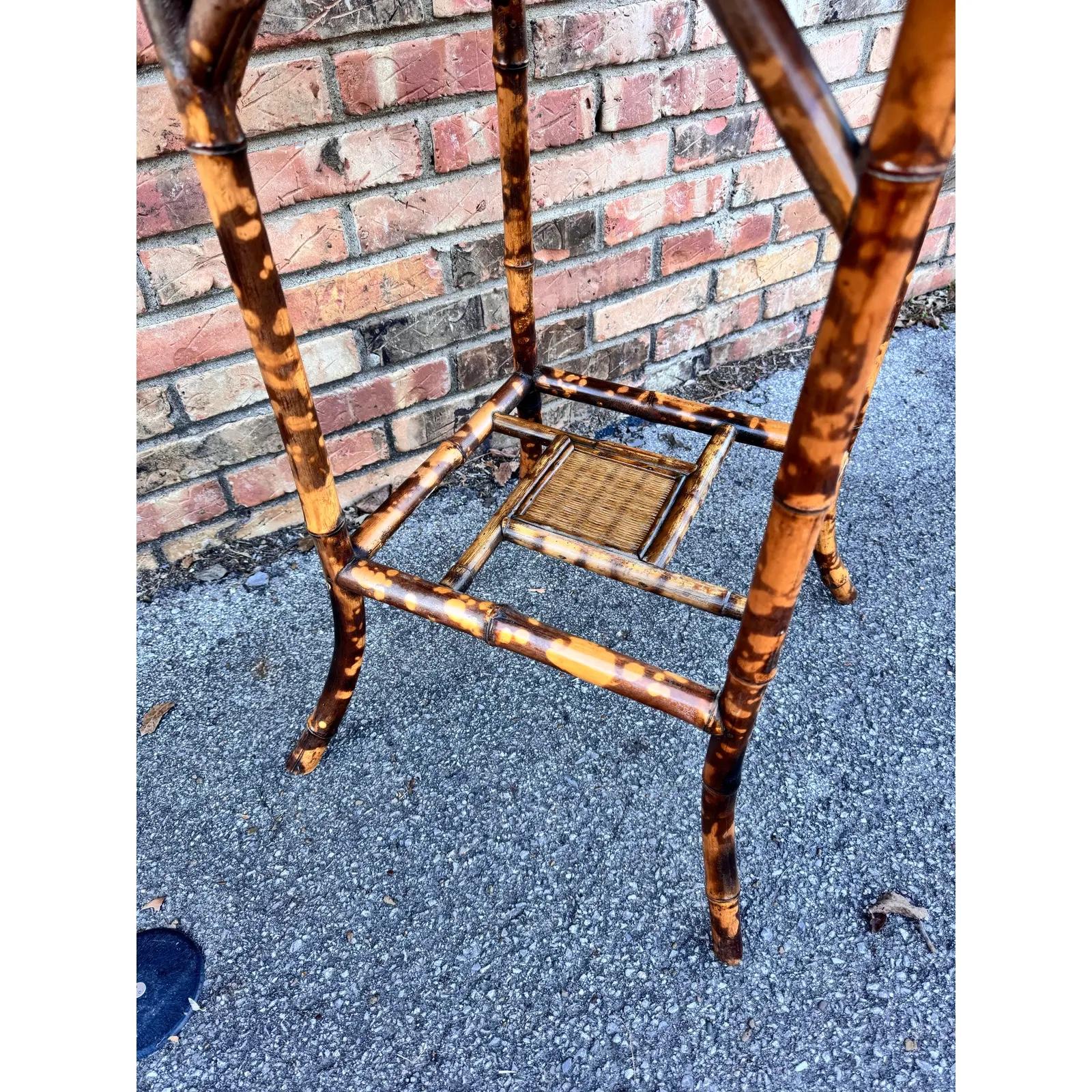 Il s'agit d'une magnifique table d'appoint en bambou anglais du 19e siècle ! Les tables de ce type constituent d'excellentes pièces d'accent, car leur couleur et leur style sont très polyvalents. Les teintes sombres du bambou brûlé se marient