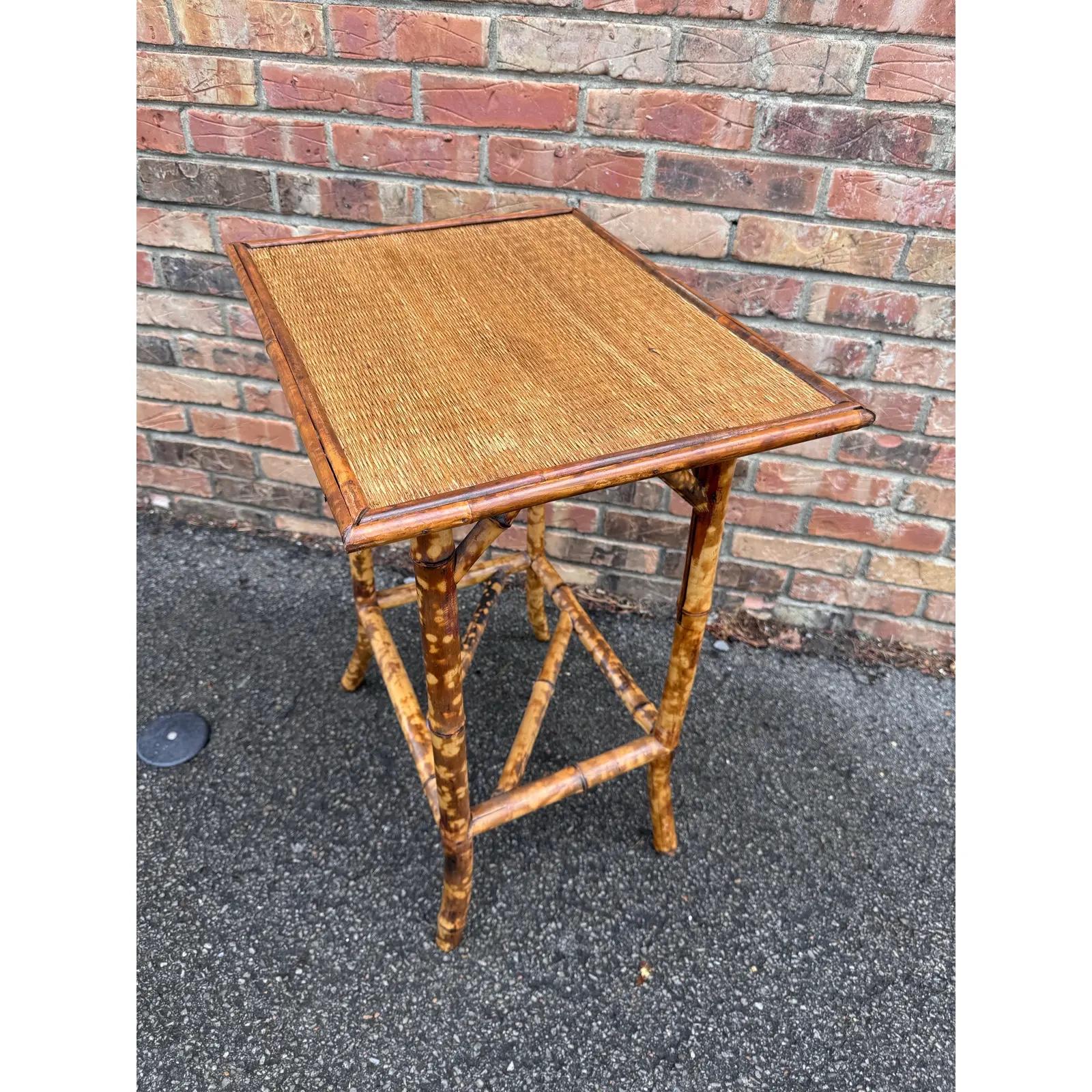 This is a beautiful 19th century English bamboo side table! Tables like these make excellent accent pieces because their color and style is so versatile. The dark hues of the burnt bamboo pair perfectly with the lighter golden of the rattan top and