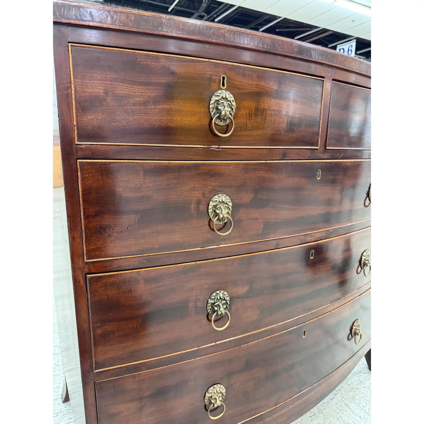 This 19th century English Bow Front Chest of Drawers is a beautifully designed piece of furniture, featuring tastefully tapered legs and finely shaped drawer fronts, and lovely inlaid detailing. It showcases excellent craftsmanship and is made from