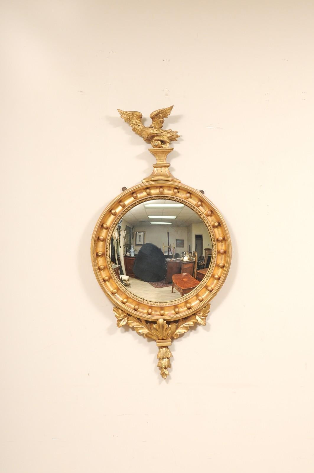 Beautiful 18th Century Regency Round Bullseye Giltwood Mirror. An Eagle mount adorns the top of the mirror, symbolizing power and victory. The frame is embellished with giltwood spheres/balls and acanthus leaves. 

Convex mirror/glass measures
