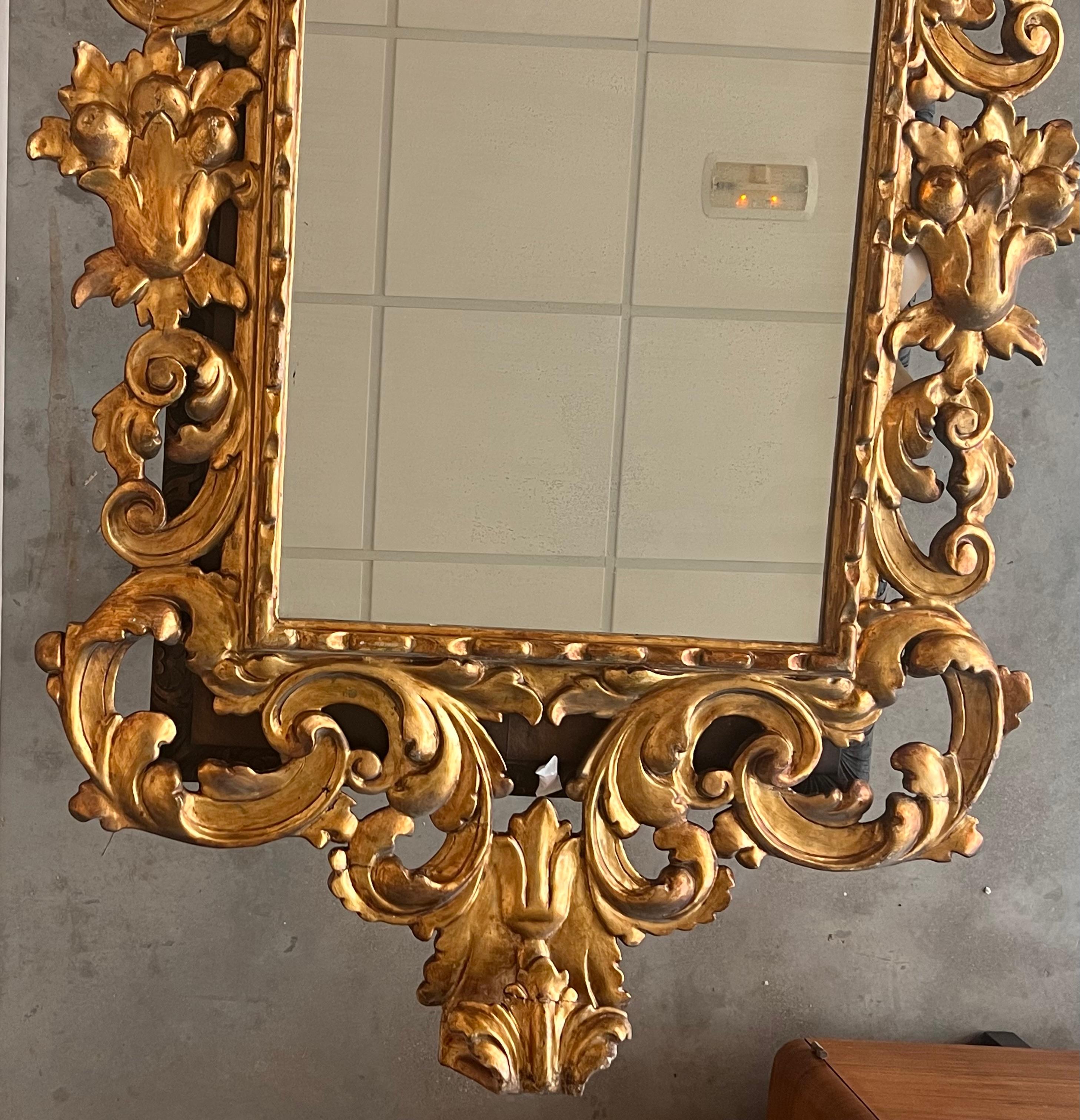 Miroir rectangulaire en bois sculpté et doré d'époque Empire du début du 20e siècle avec écusson
Exceptionnel miroir italien sculpté et doré à la main. Hautement sculpté avec des fleurs, verre d'origine (peut-être réargenté) et dos en bois