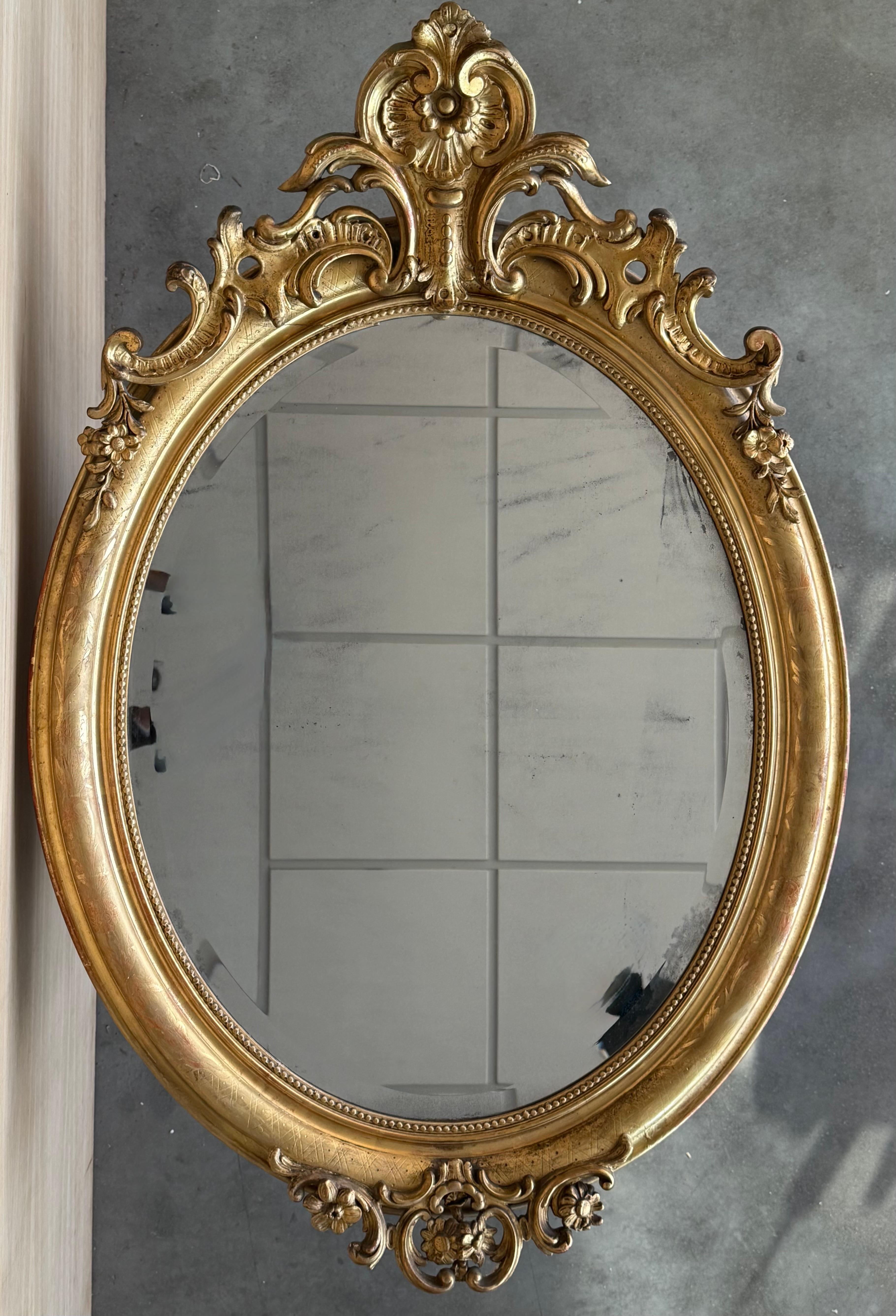 Specchio ovale in legno dorato di epoca Impero del XIX secolo 
