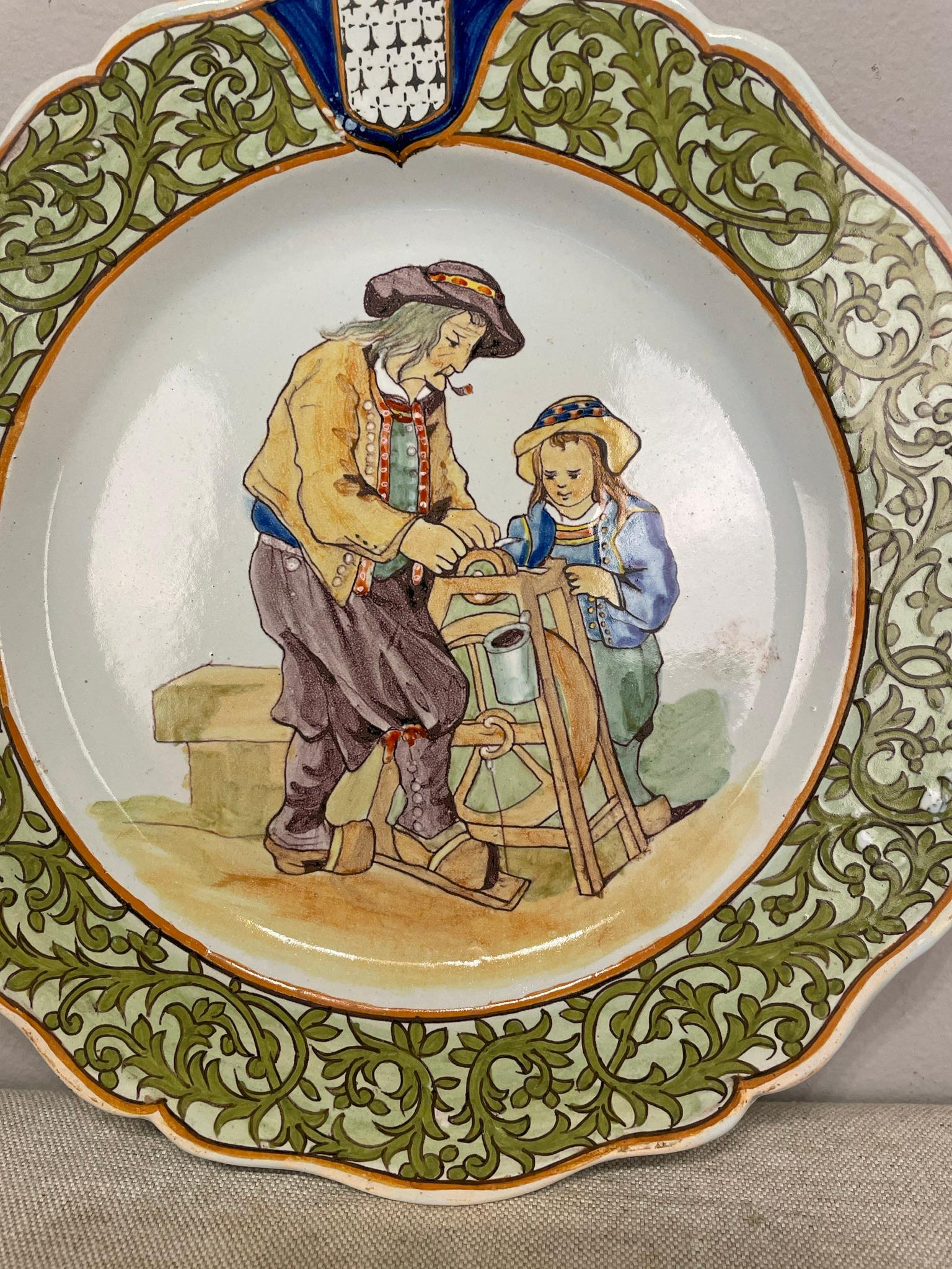 A good 19th century French Porquier Beau Quimper plate with a green border depicting a man with a your child sharpening a knife. good details and in no chips nor hairline.
Signed on the back. Minor wear. 
Dimensions are 9.25
