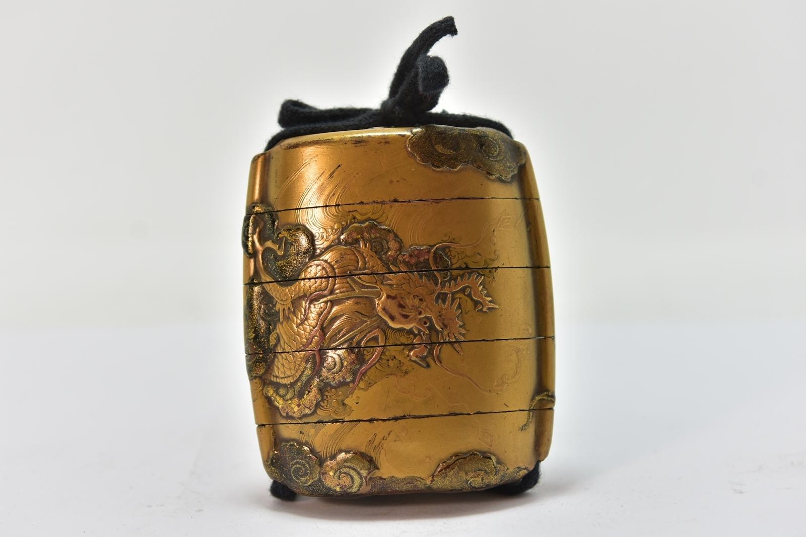 Inro giapponese del XIX secolo con 4 scatole in lacca dorata con sfondo kinji mat decorato in taka makiyé d'oro di diverse tonalità. Dimensioni del legno laccato. Peso 47,5 gr. Drago che appare in mezzo alle nuvole. Periodo del XIX secolo.