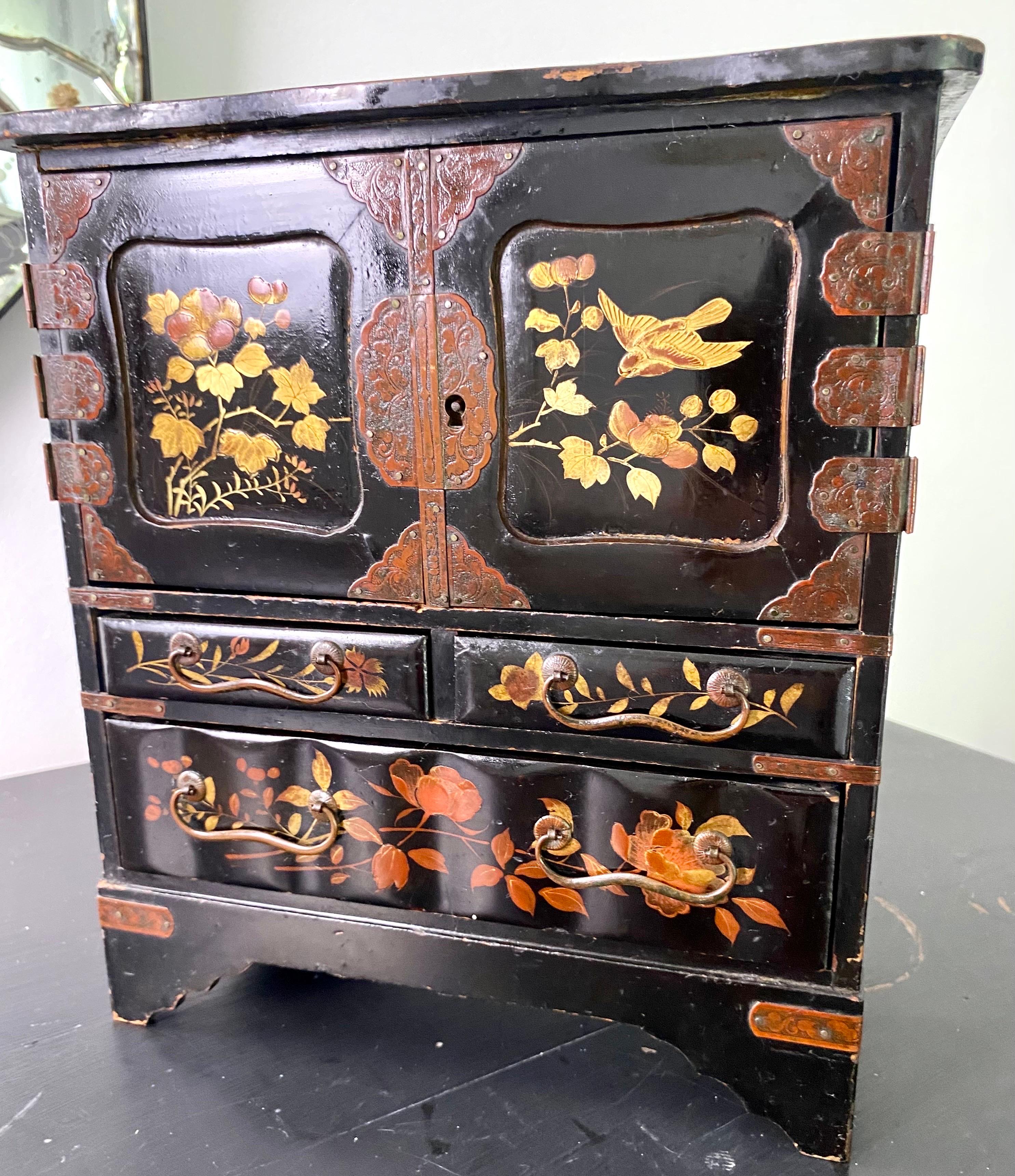 Small Japanese temple cabinet in black lacquer with gilding.
Decorated with birds and Asian landscapes. This plant decoration is particularly common in Japanese iconography, and symbolizes the arrival of spring.
The cabinet contains 7 drawers: 2