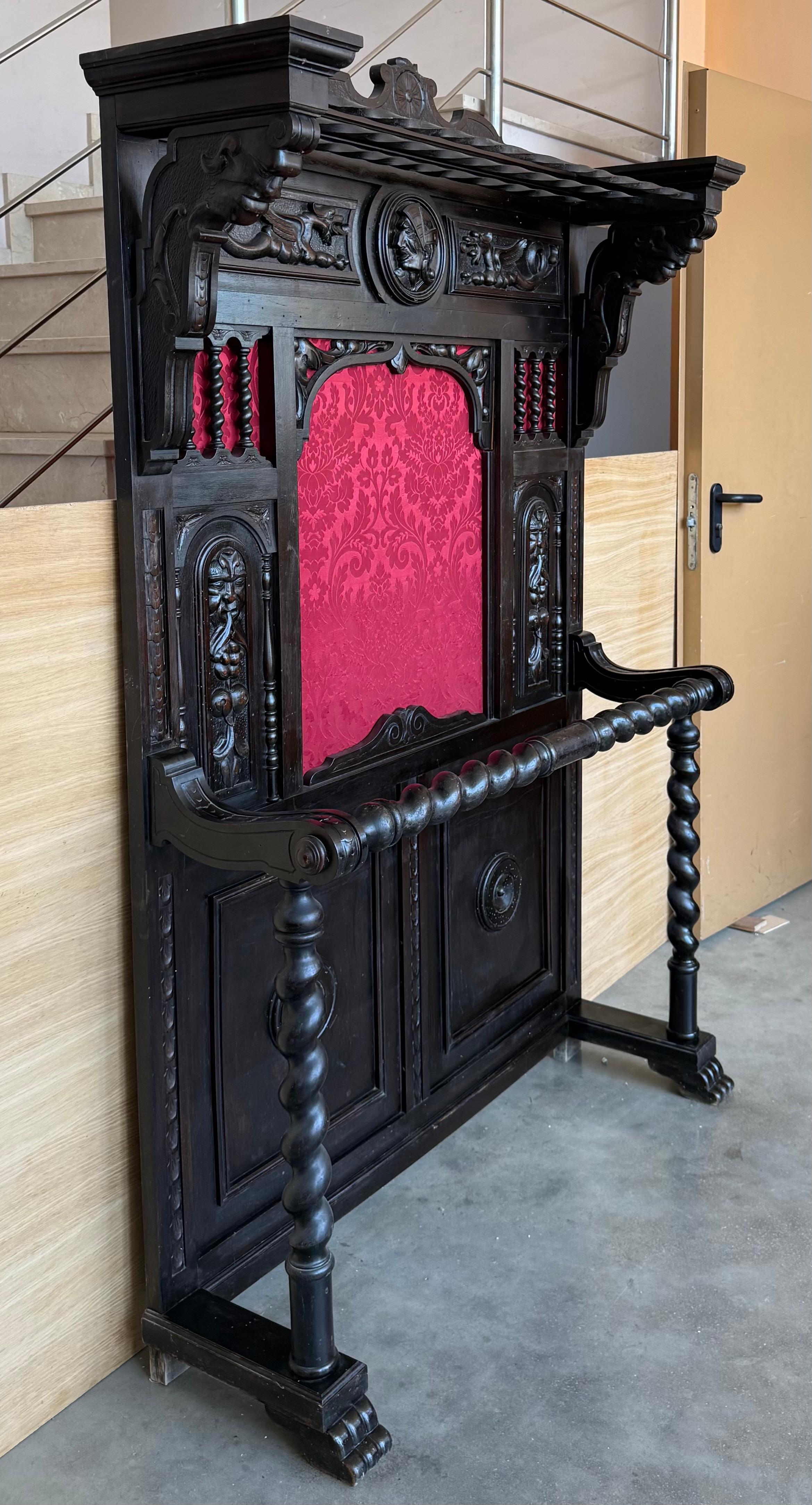 Il grande appendiabiti in noce massiccio spagnolo intagliato è dotato di tutta la ferramenta originale, che è in ghisa pesante ed è stata lucidata e laccata per facilitarne la manutenzione. La metà superiore è riccamente scolpita con urne intricate,