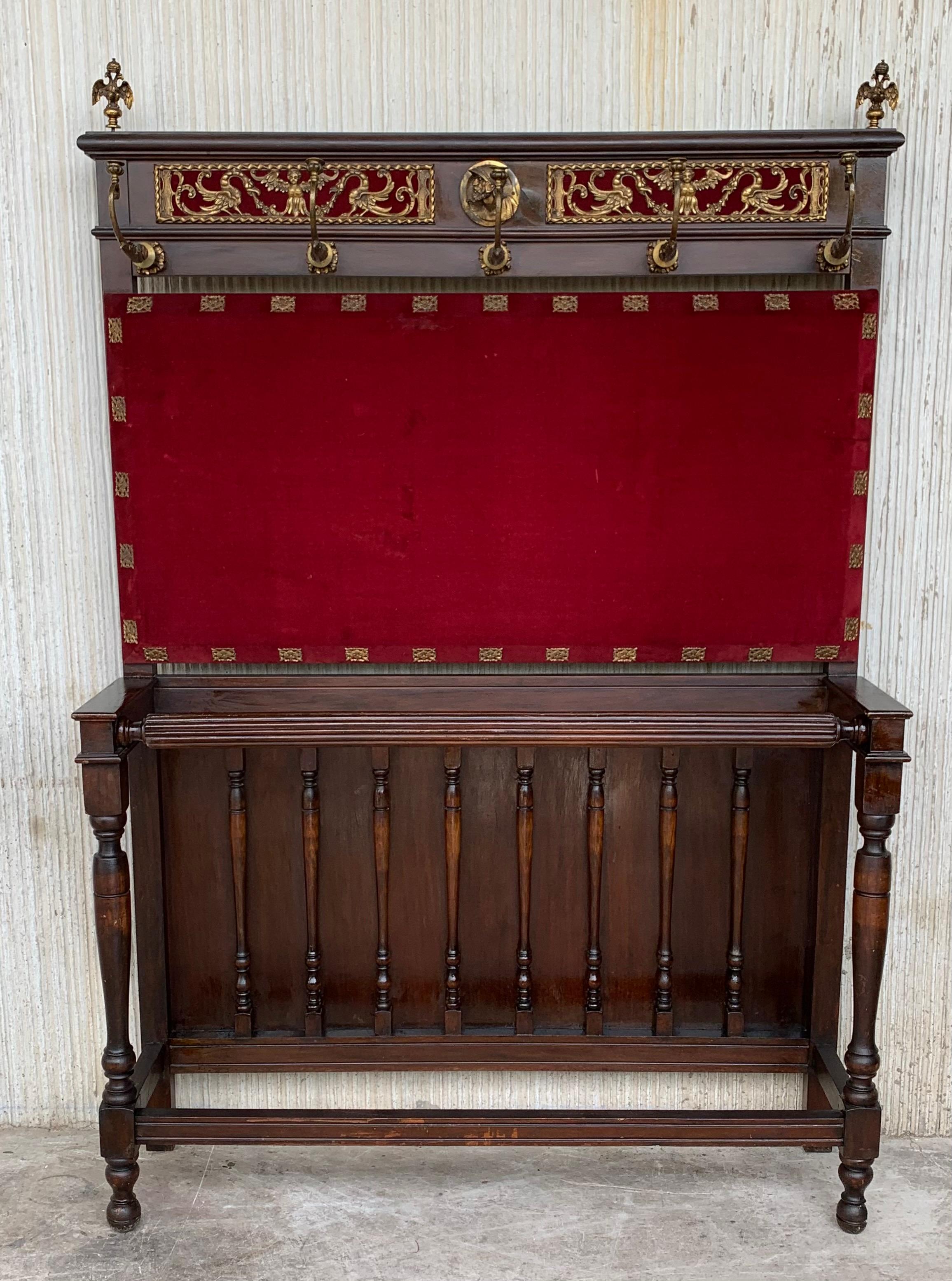 Ce grand porte-manteau en noyer massif espagnol sculpté possède toutes les pièces d'origine en fonte lourde, qui ont été polies et laquées pour un entretien facile. La moitié supérieure est abondamment sculptée d'urnes complexes, d'arabesques et de