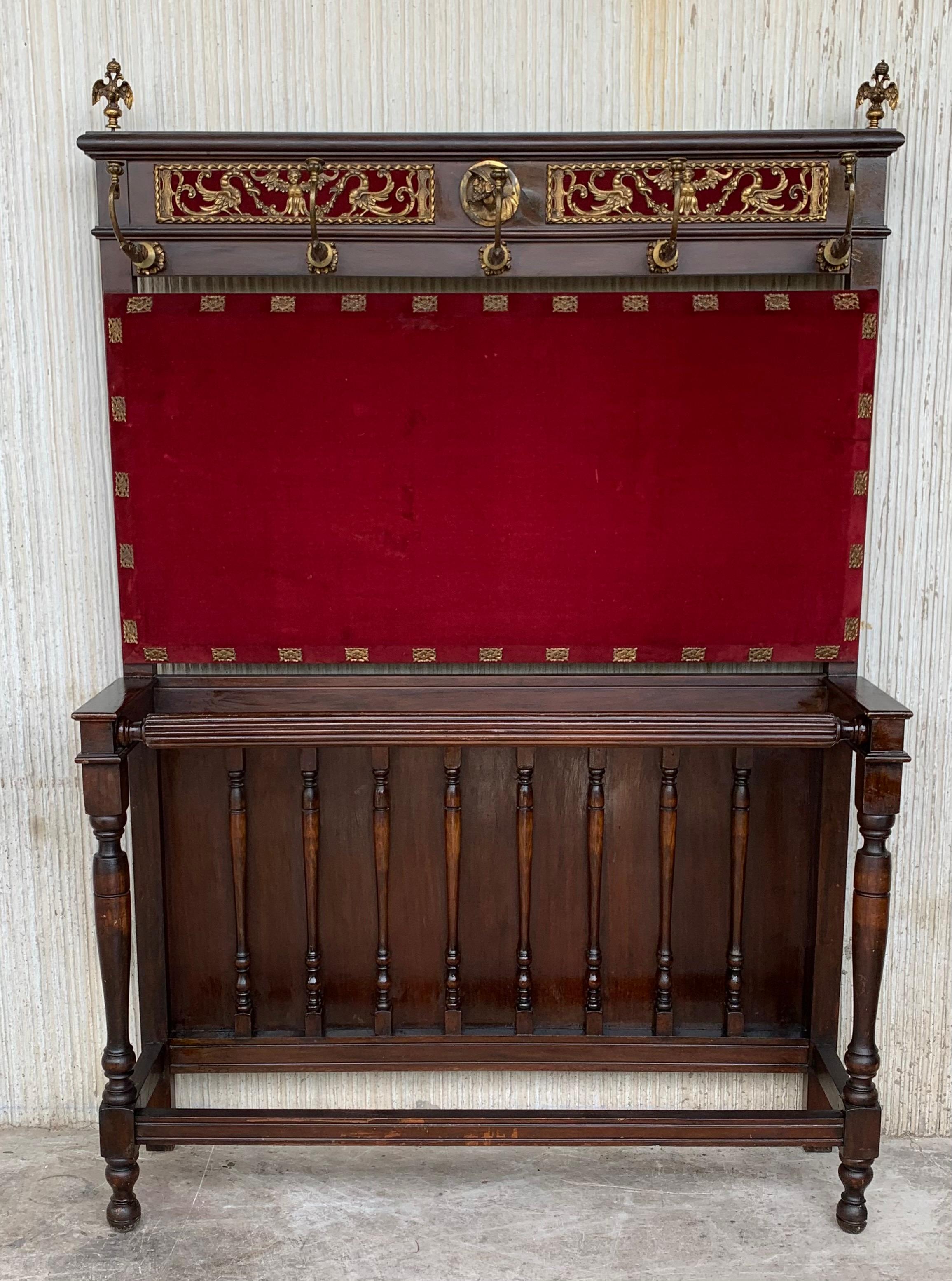 Large carved Spanish solid walnut coat rack stand has all of the original hardware which is heavy cast iron and has been polished and lacquered for easy maintenance. The top half is profusely carved with intricate urns, arabesques, and baskets of