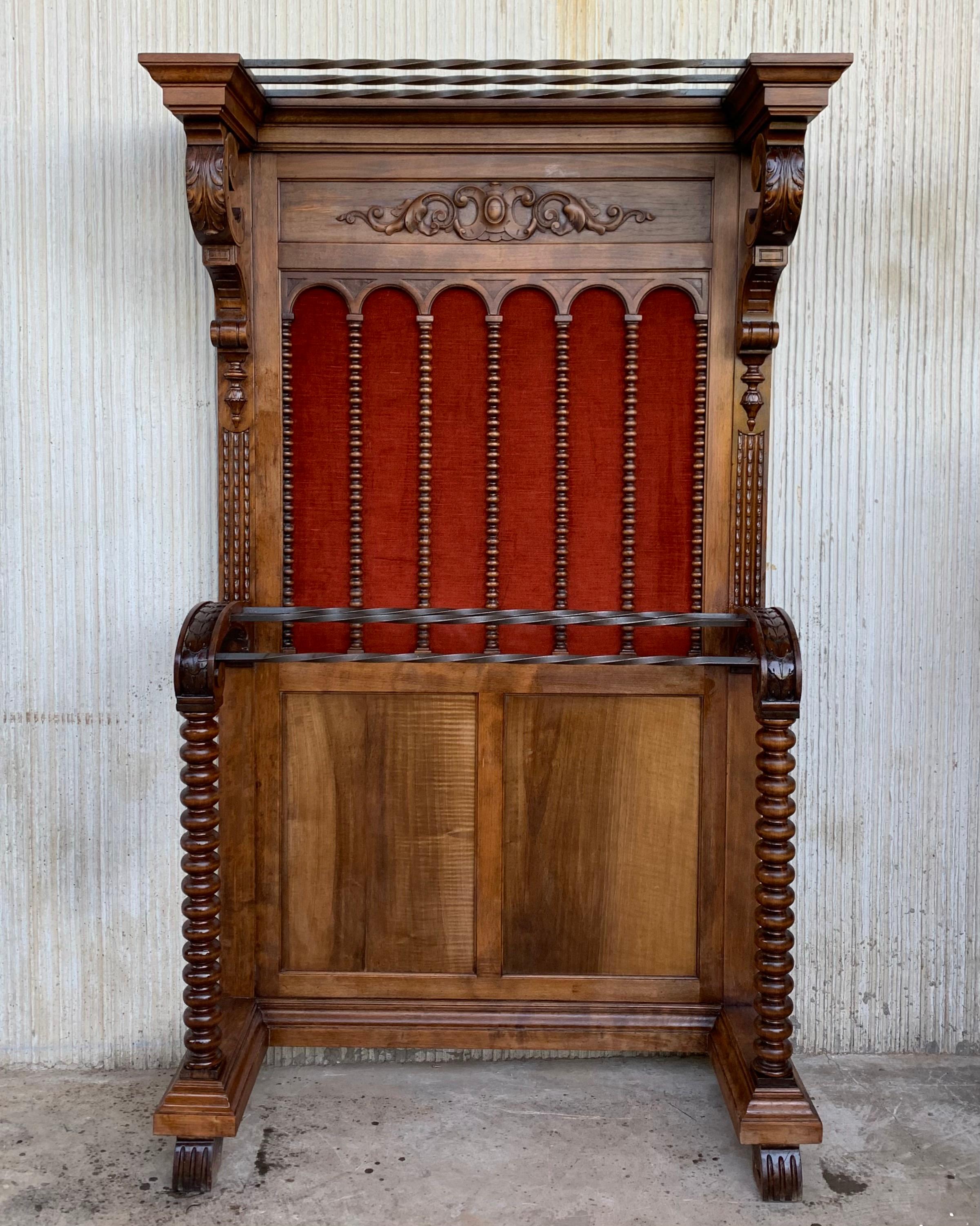 Large carved Spanish solid walnut hall stand has all of the original hardware which is heavy cast iron and has been polished and lacquered for easy maintenance. The top half is profusely carved with intricate urns, arabesques, and baskets of grapes