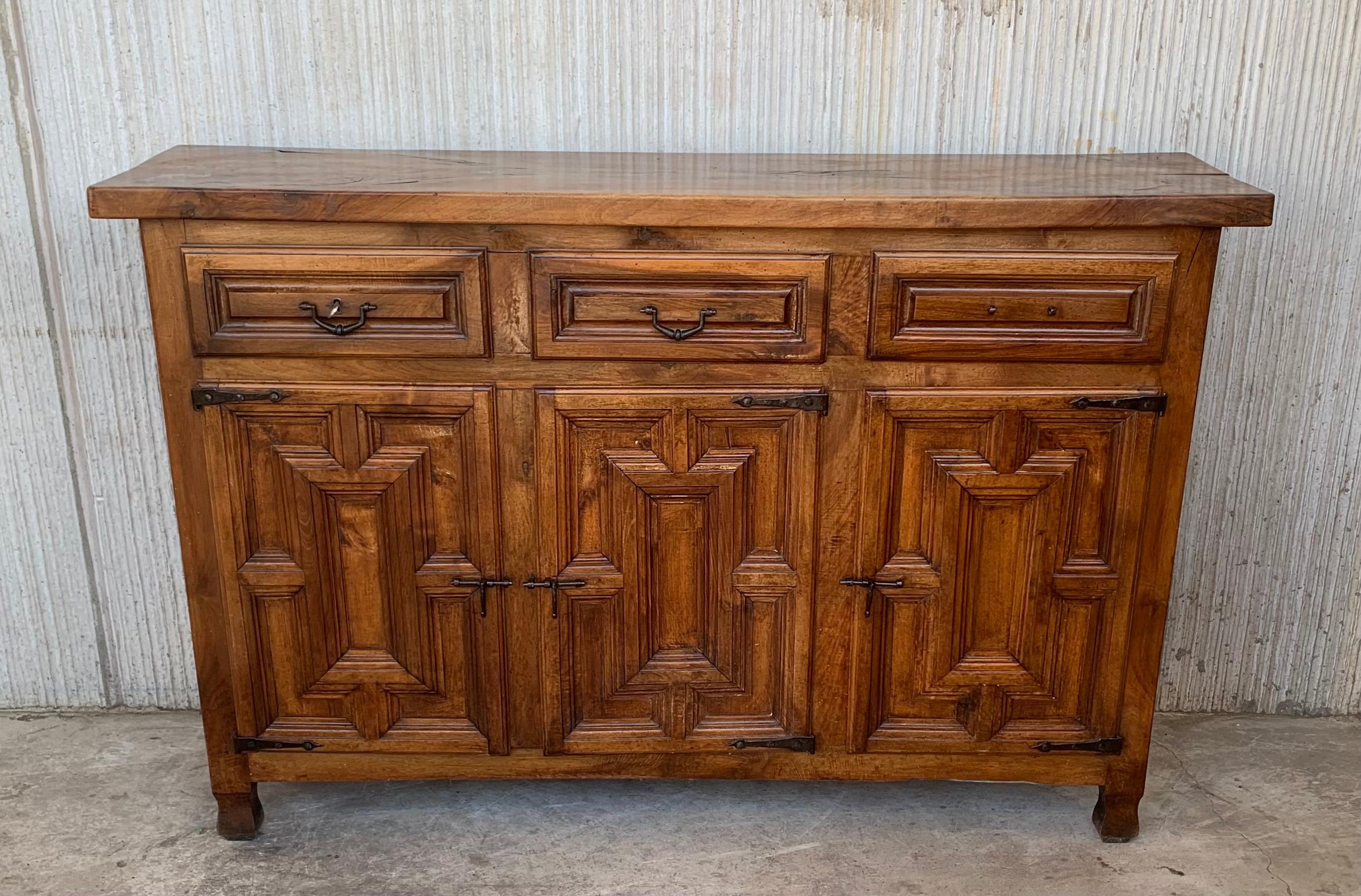 From Northern Spain, constructed of solid oak, the rectangular top with molded edge atop a conforming case housing three drawers over three doors, the doors paneled with solid walnut, raised on a plinth base.
The 1st drawers has a working lock with