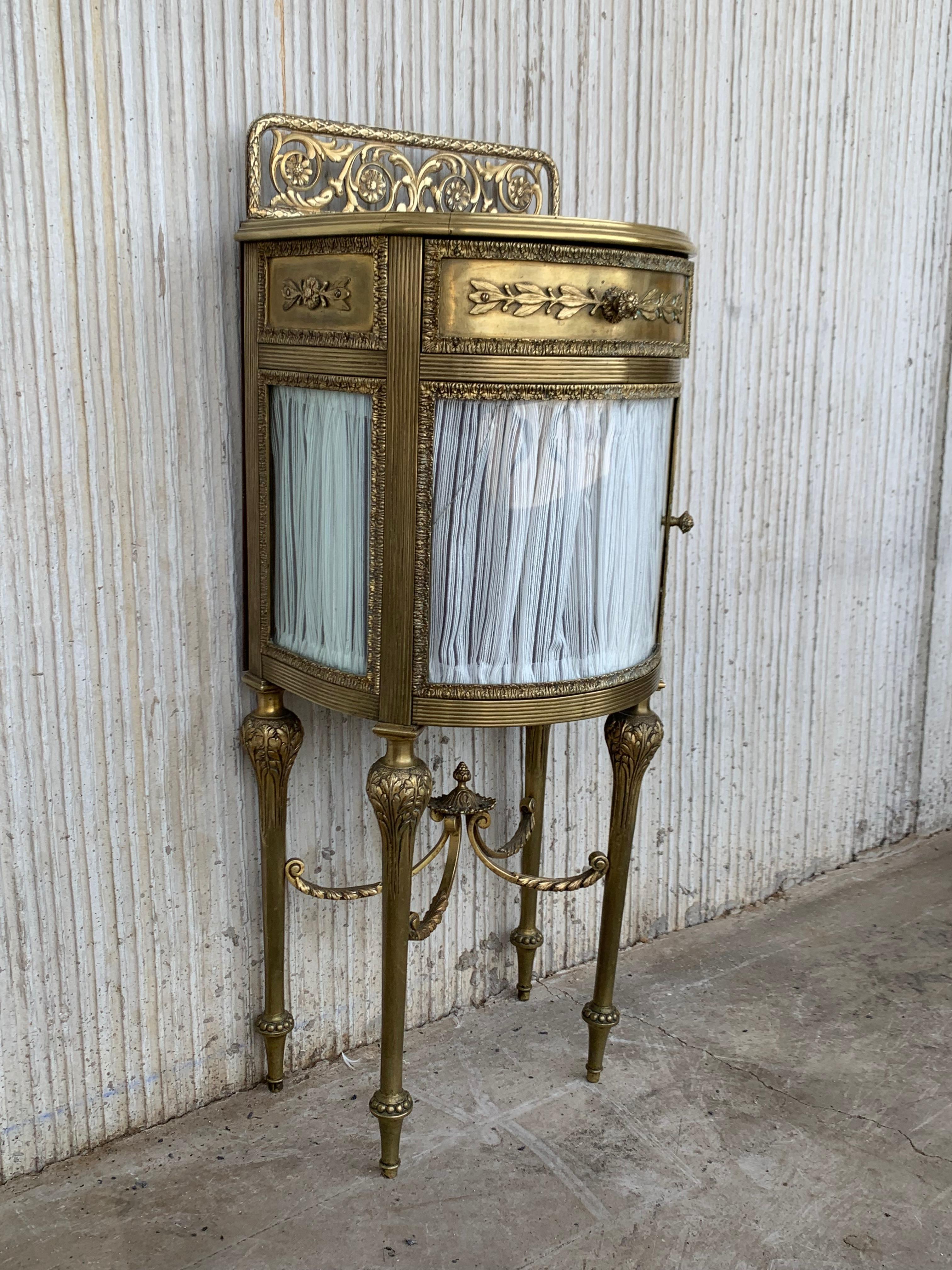 19th century pair of bronze nightstands with curved glass door and drawers.

This early antique Louis XVI style bronze or glass vitrine cabinet or nightstand is simply stunning and constructed of the finest quality. The bronze mounts of fine form