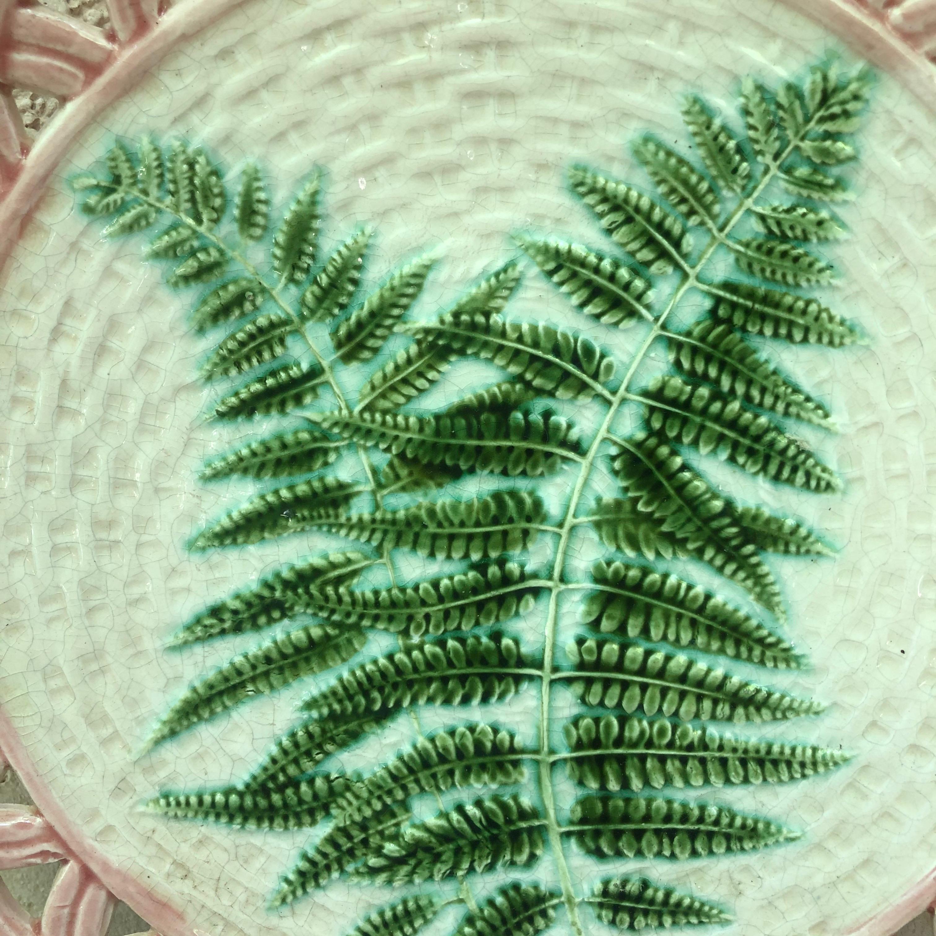 French 19th century Majolica reticulated plate signed Sarreguemines.
Decorated with larges ferns on a beige basket weave background, delicate pink reticulated border.