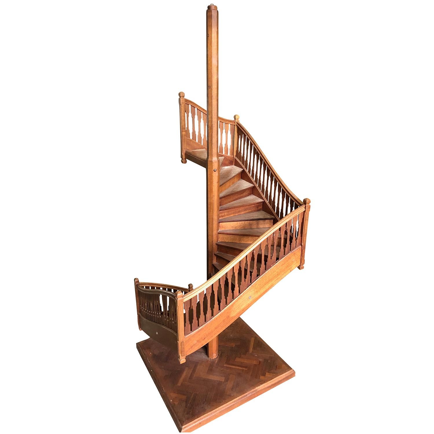 Escalier en colimaçon ancien en noyer marron, décor de style classique avec de nombreuses marches et des supports de balustres plats sur une base carrée, dans un motif à chevrons, en bon état. Les escaliers miniatures ont été produits par des