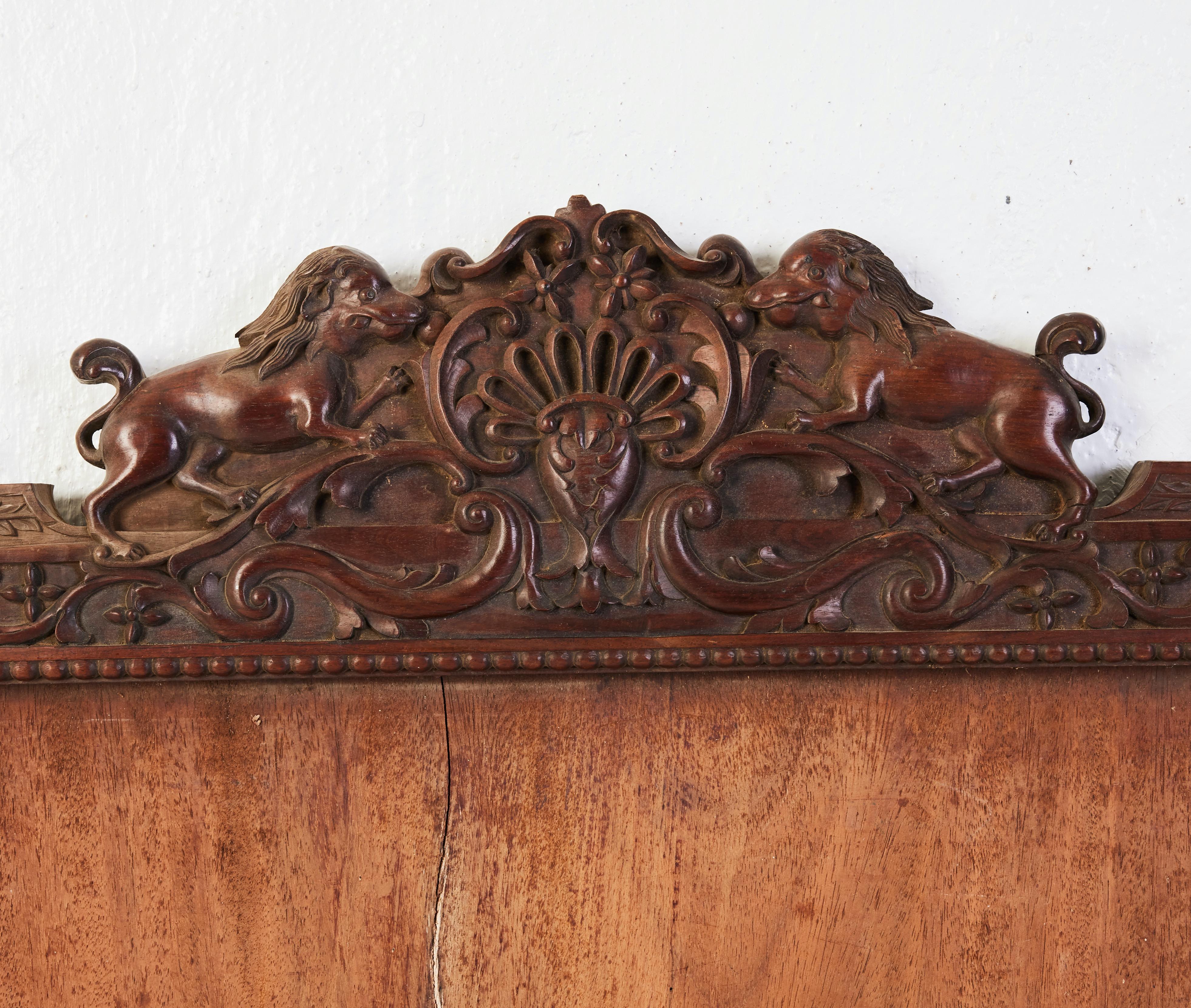 A large 19th or 20th century Asian, possibly Chinese, carved mirror frame. Heavy Asian wood. The top with carving similar to a crest and two Foo dogs facing each other. Probably made for export. Possibly originally with a painted mirror glass. The