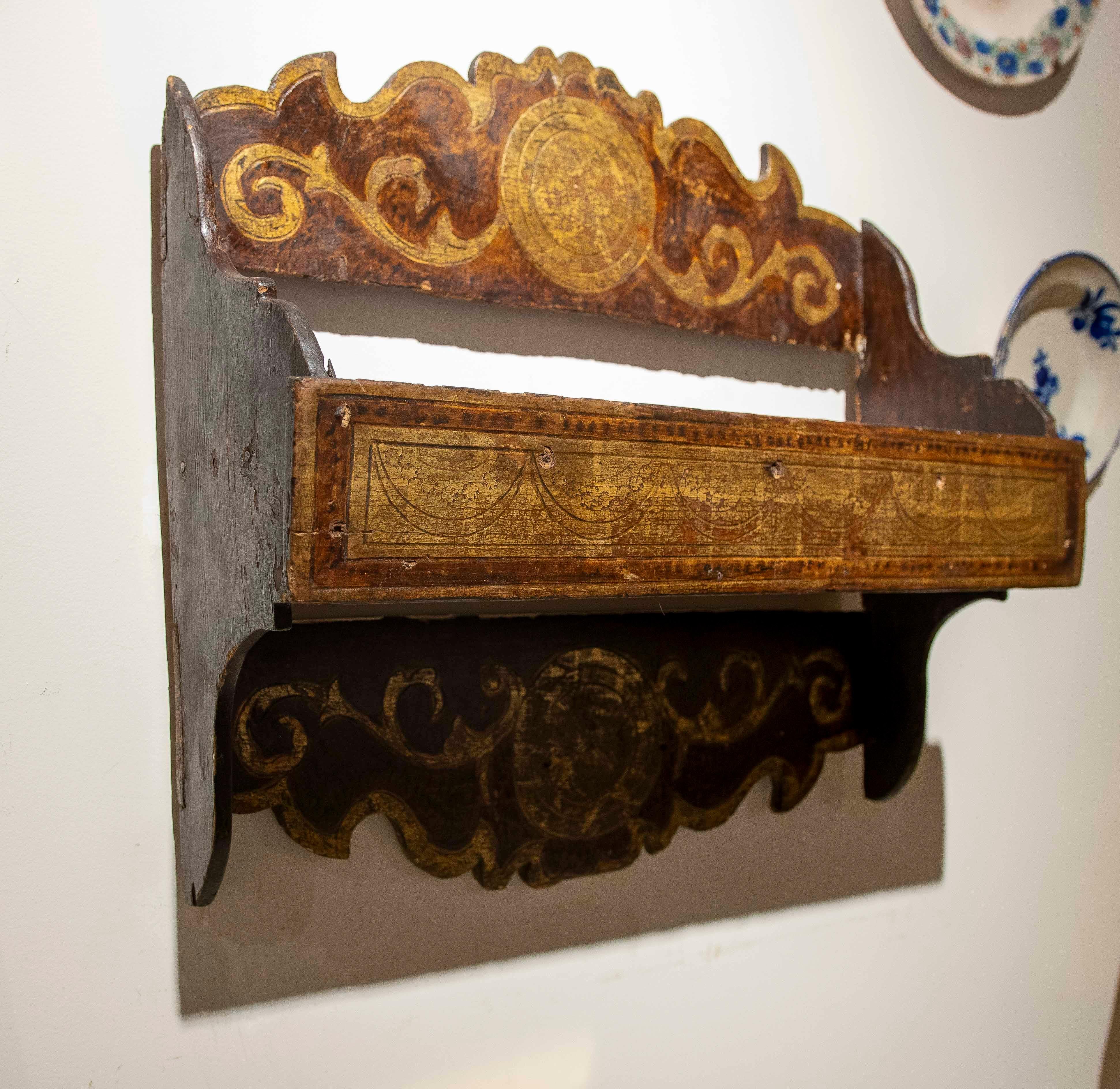 19th-century Spanish spice rack, made of carved wood and decorated with painted and gilded motifs. The piece features a simple and functional structure, embellished with rocaille ornamentation and gold-leaf medallions, reflecting the Iberian artisan