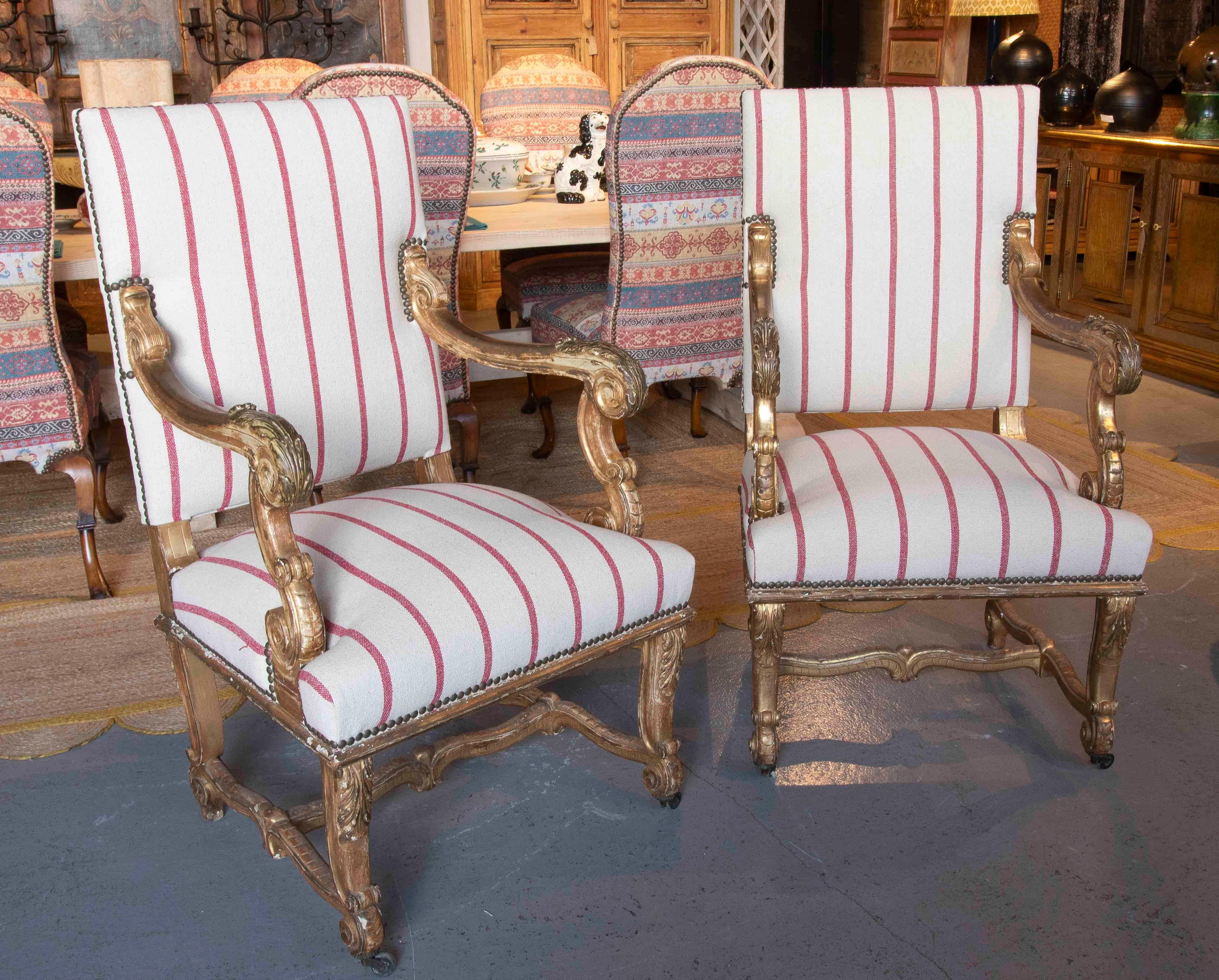 Un'elegante coppia di poltrone in stile Luigi XV francese del XIX secolo, realizzate in legno intagliato e dorato. Le cornici presentano delicati intagli a rilievo con motivi vegetali e volute, caratteristici dell'opulenza dell'epoca.

Di recente