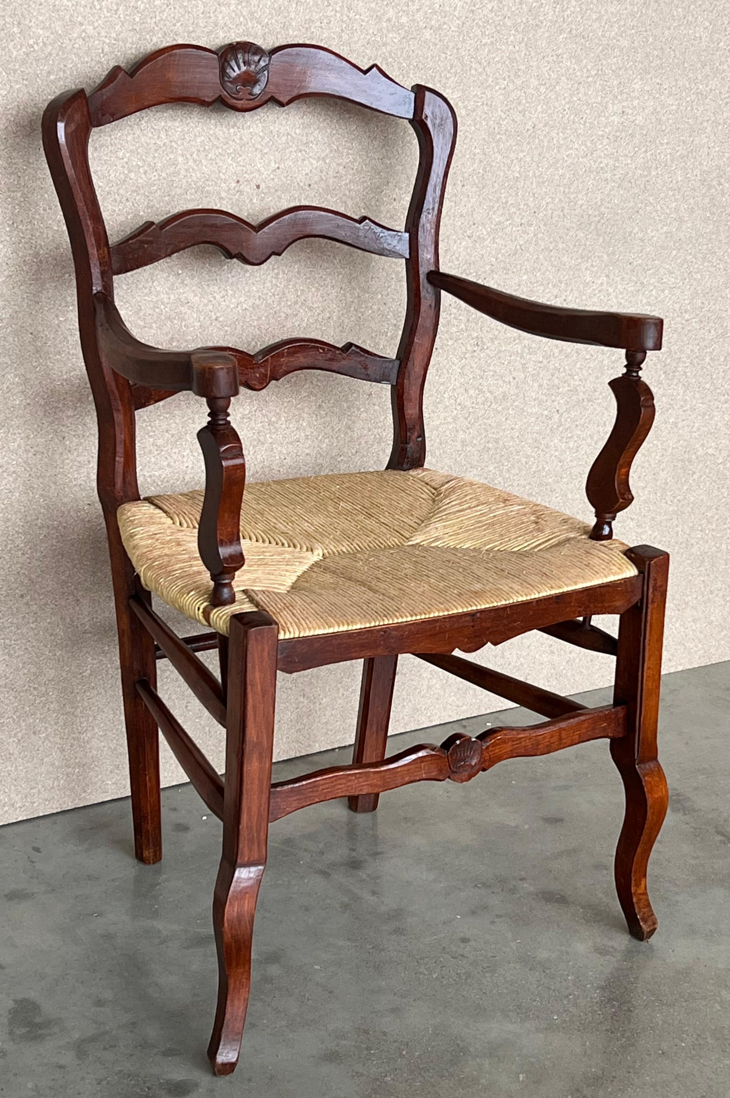 Fauteuils espagnols du 19e siècle, sculptés, avec assise en jonc d'origine. Fantastique surface intacte avec des bras usés. Très confortable et en bon état. Superbe look western. Tous les objets tournés sont sculptés à la main.