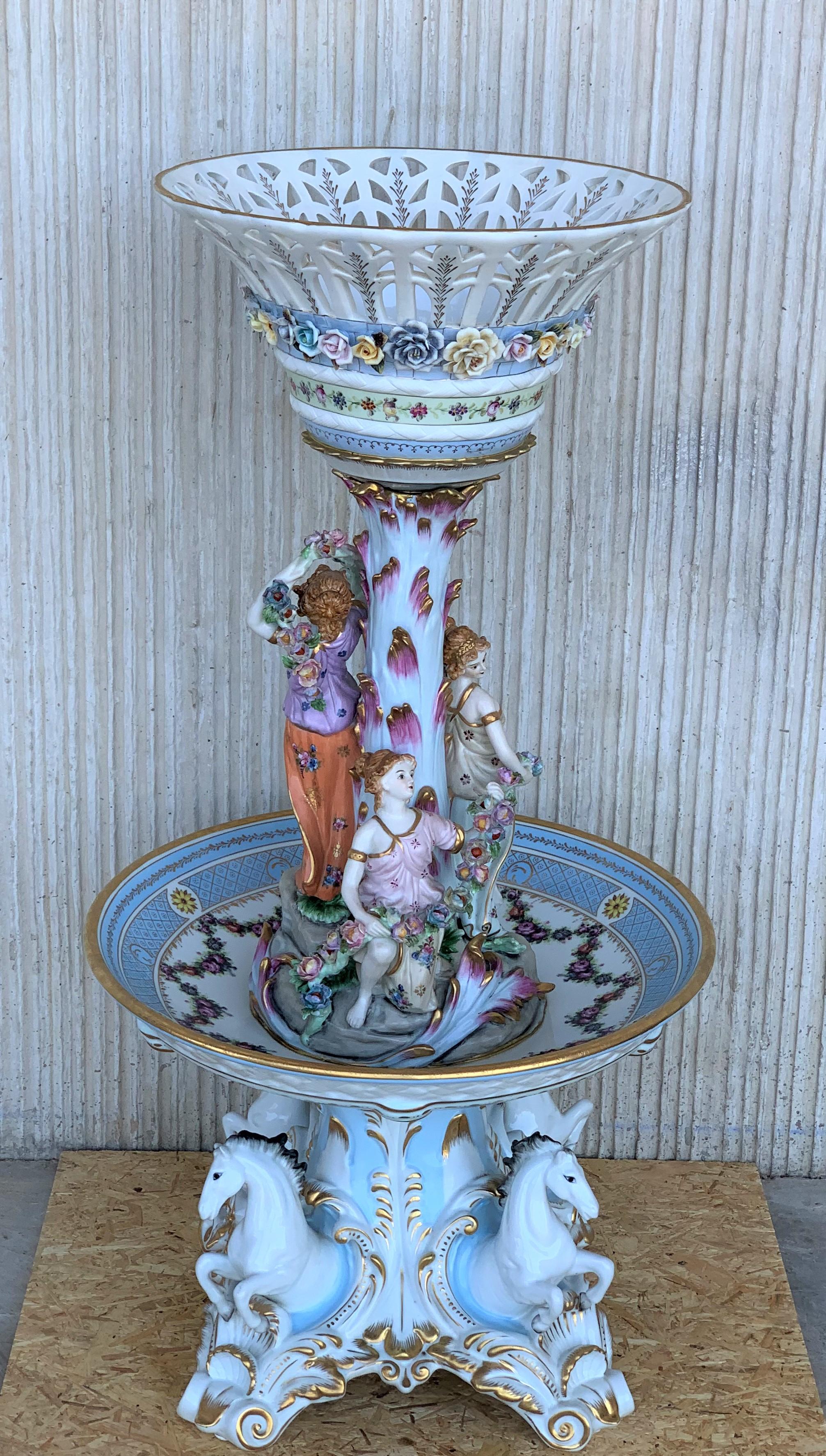Serving piece, fruit bowl center table with 1 plates and 1 high, basfuit basket in enameled porcelain.
This highly decorative footed bowl, reticulated and painted with female figures adorned with flowers, is raised on a charmingly decorative base