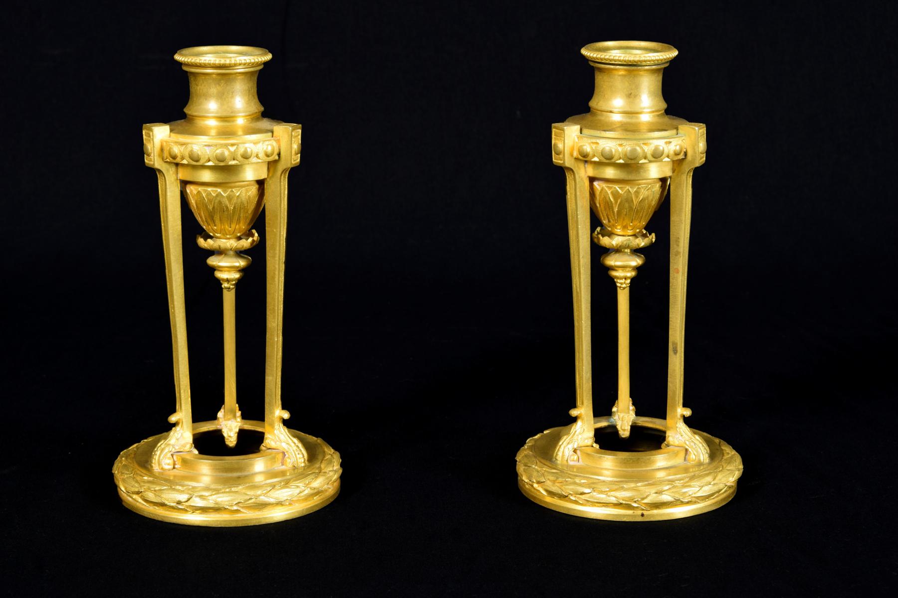 19th century, small pair of French chiseled gilded bronze candlesticks

The elegant and refined pair of bronze candlesticks finely chiselled and gilded was made in France circa mid-19th century in Louis XVI style.
The tripod-shaped objects have a