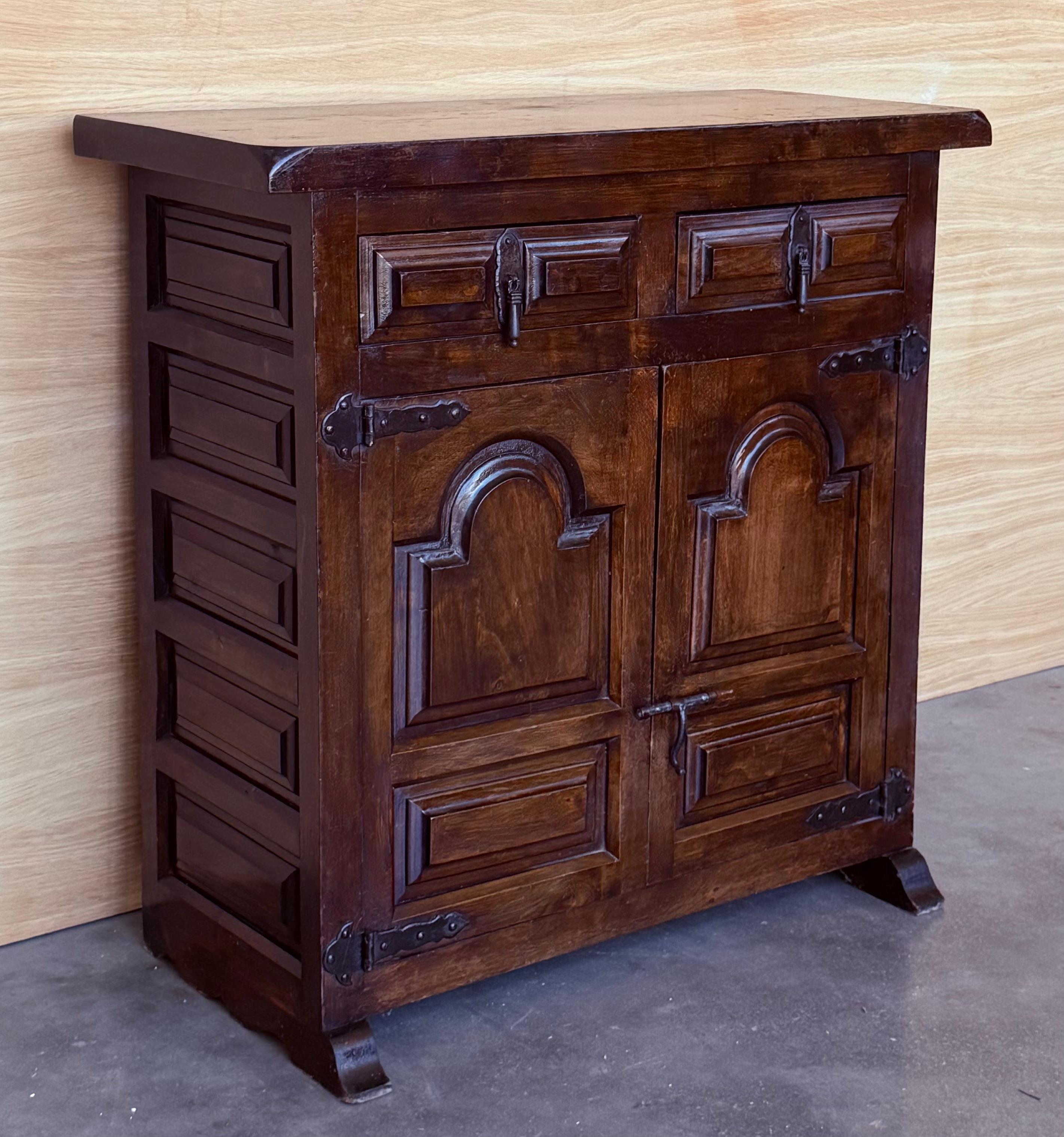 From Northern Spain, constructed of solid walnut, the rectangular top with molded edge atop a conforming case housing two drawers over two doors, the doors paneled with solid walnut, raised on a plinth base.
Beautiful carved drawers and original