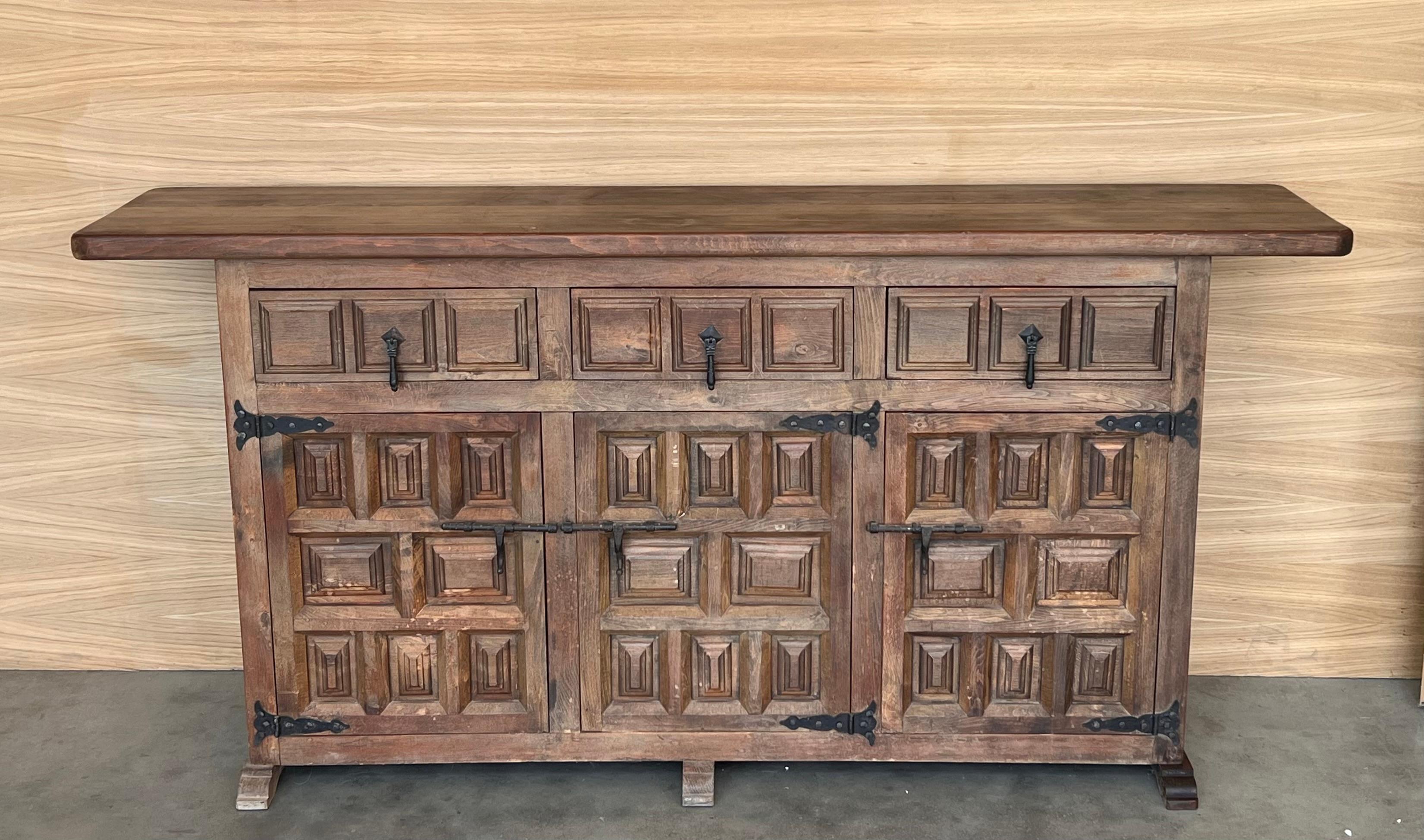 From Northern Spain, constructed of solid walnut, the rectangular top with molded edge atop a conforming case housing two drawers over two doors, the doors paneled with solid walnut, raised on a plinth base.
Beautiful carved drawers and original