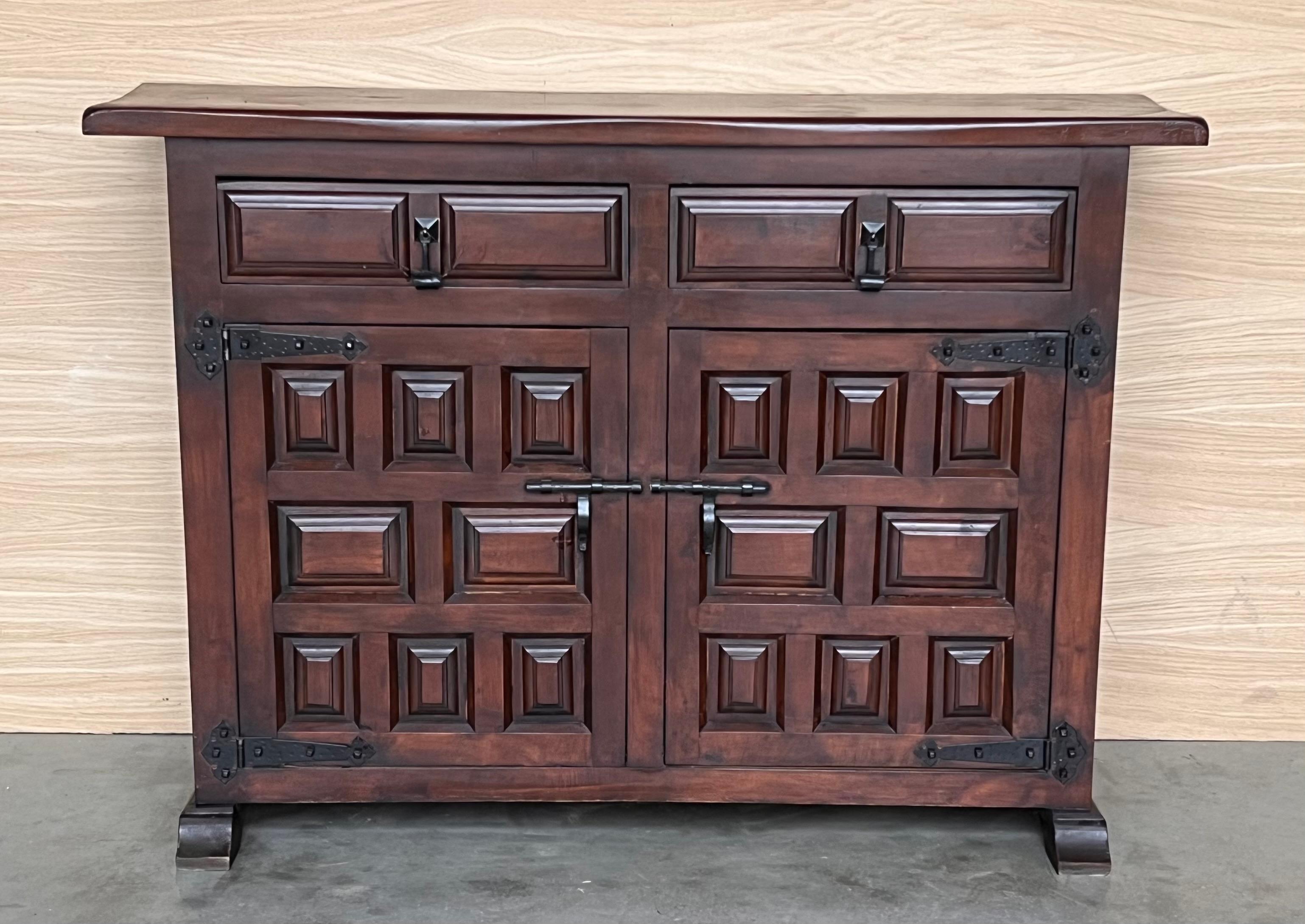 From Northern Spain, constructed of solid walnut, the rectangular top with molded edge atop a conforming case housing two drawers over two doors, the doors paneled with solid walnut, raised on a plinth base.
Beautiful carved drawers and original
