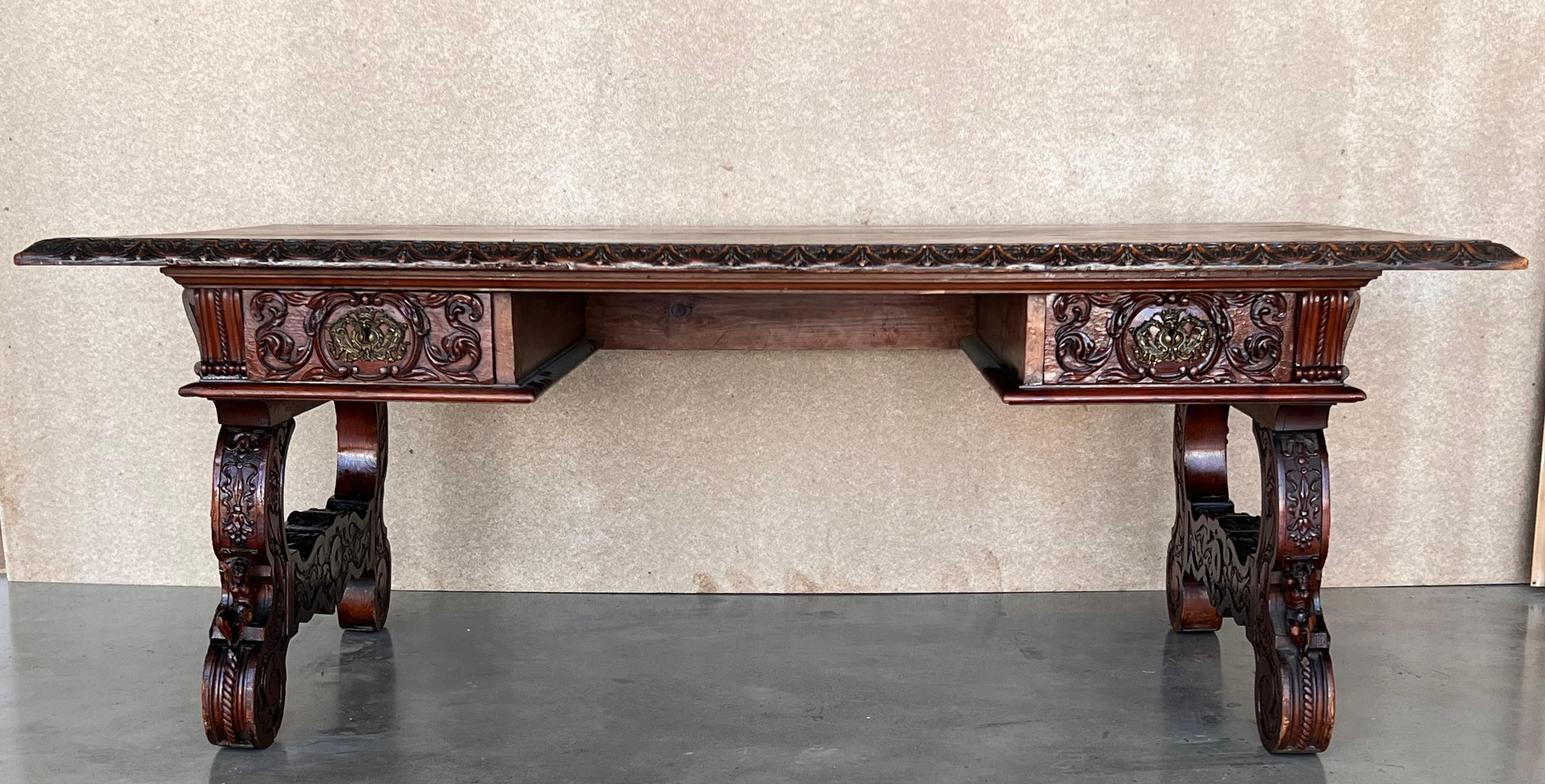 In grand, gothic style, this Spanish library / writing table has a deeply carved edge and this is just the tip of the proverbial iceberg, as the carving never really stops. It goes on from the frieze, down along the shaped lyre legs and continues to