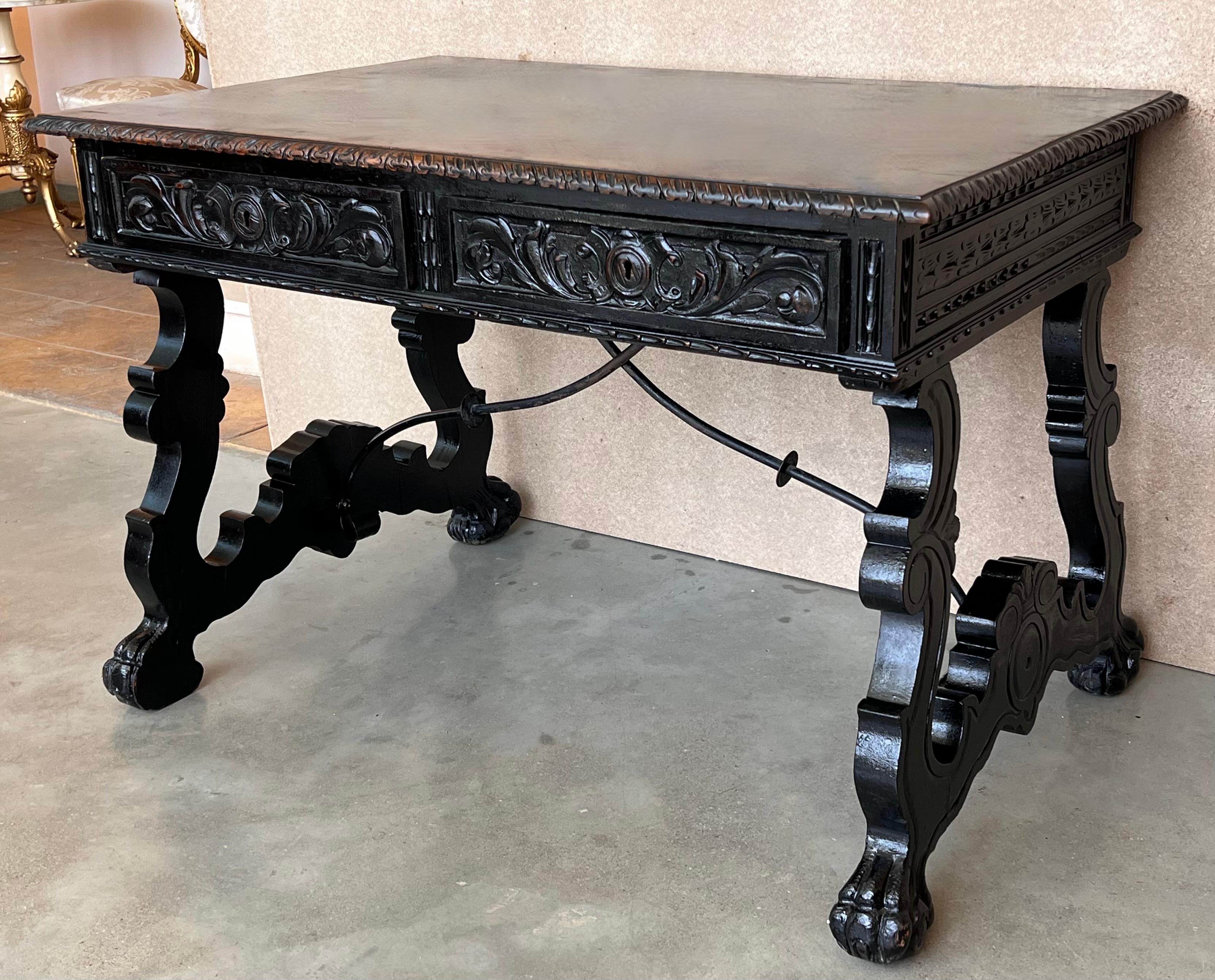 In grand, gothic style, this Spanish library / writing table has a deeply carved edge and this is just the tip of the proverbial iceberg, as the carving never really stops. It goes on from the frieze, down along the shaped lyre legs and continues to