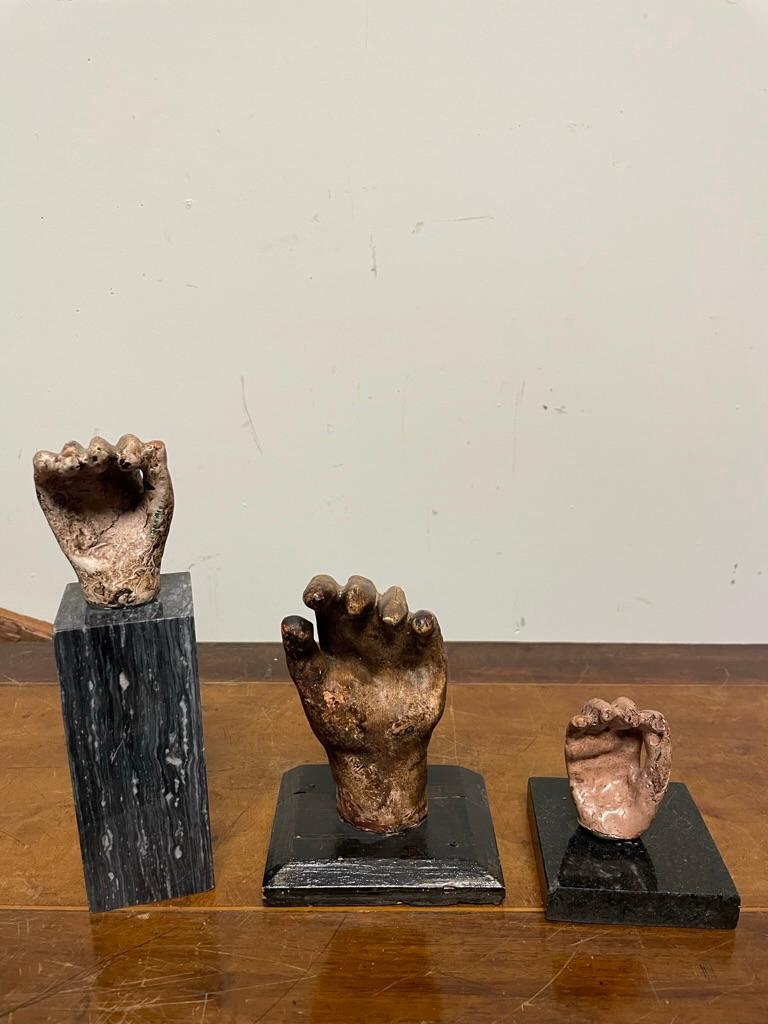 Interesting and unusual group of three Spanish Colonial painted plaster hands, two mounted on marble bases and one on a custom wood stand. Whimsical, or just creepy, they are uniqiue. Likely hands from santos figures, which often break off. The