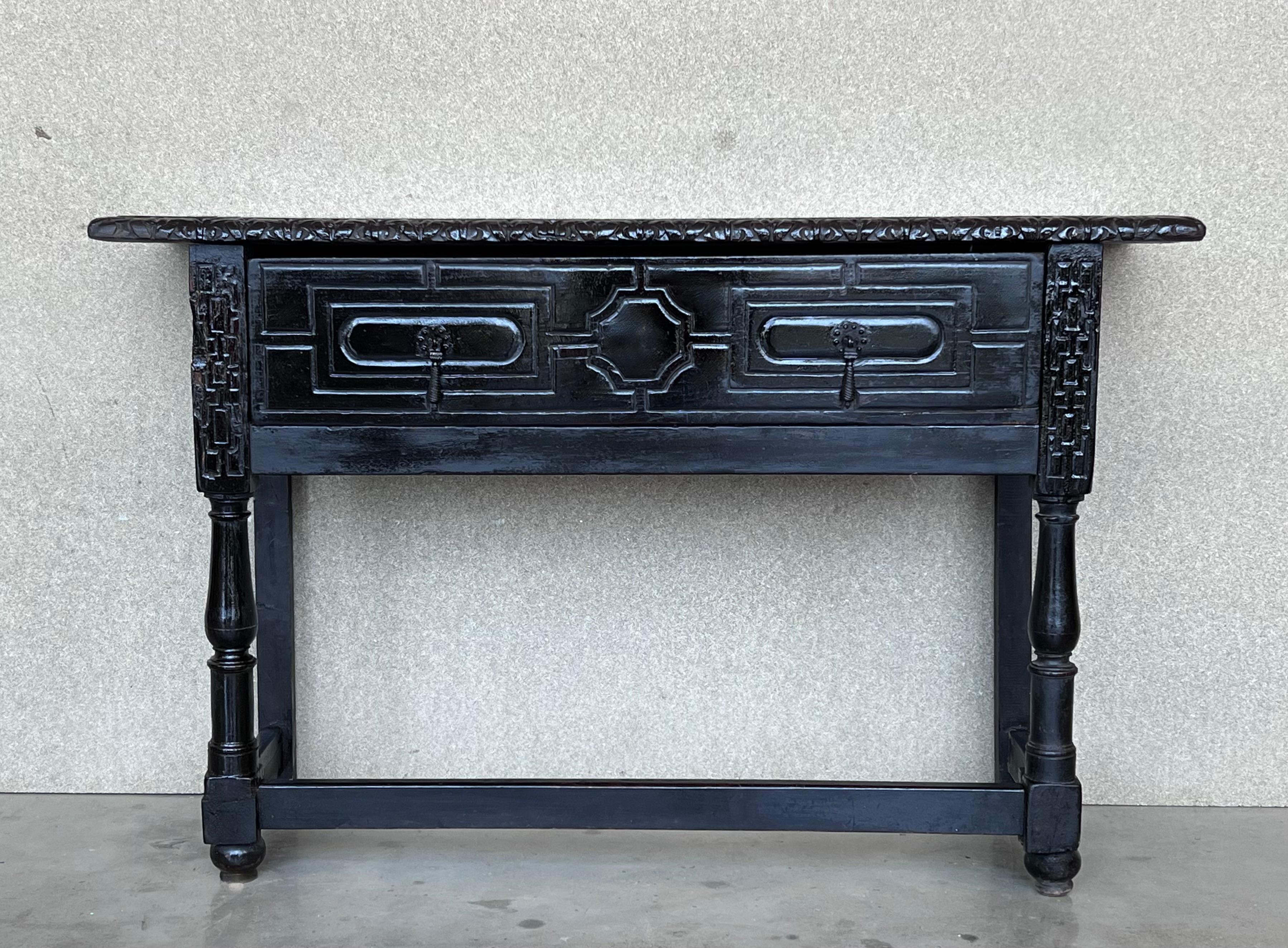 This large Spanish 19th century features a beautiful one plank rectangular top over a carved drawer featuring slightly different hardware, is adorned with geometrical motifs and their original handmade drop pulls.
Black ebonized walnut in all the